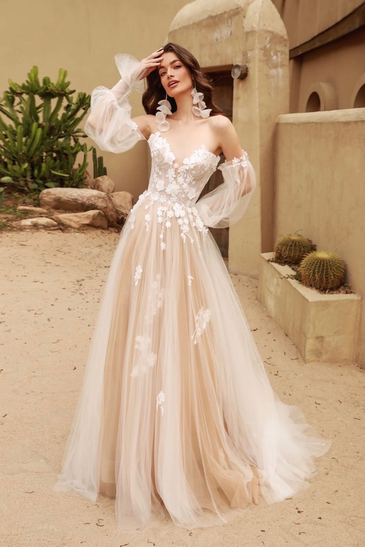 Woman in a white strapless mermaid gown posing indoors by large windows.