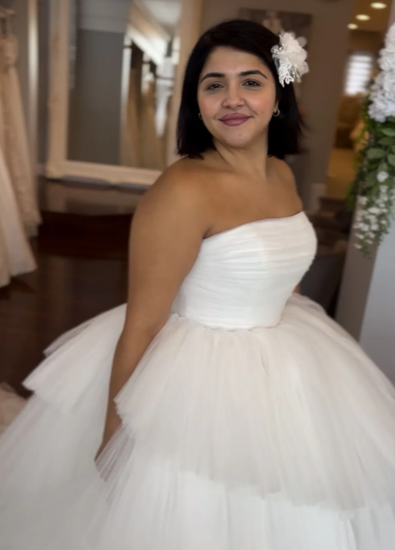 A woman in a wedding dress is holding a bouquet of flowers.