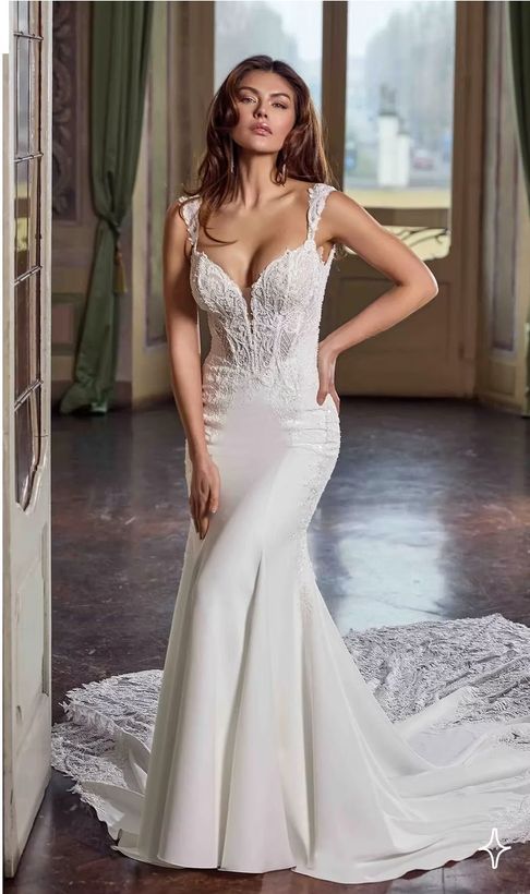 A woman in a white wedding dress is standing in a room.