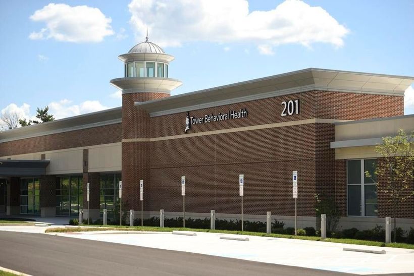 Brick building with glass entry and cupola, marked “201,” under a bright blue sky.