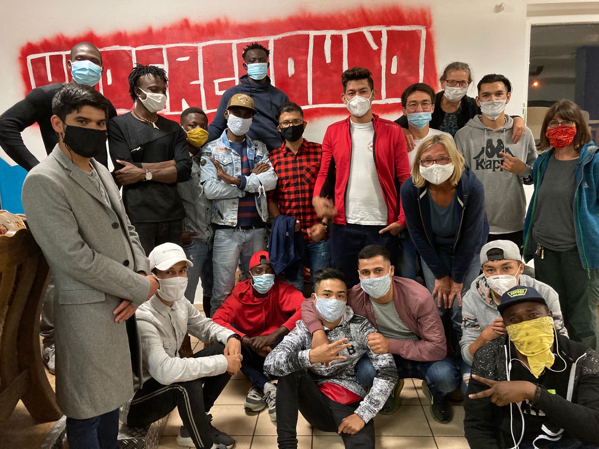 Gruppenfoto Besucher und Jugendliche in Regen mit Corona-Masken