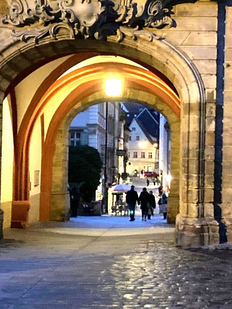Menschen beim Spaziergang unter Torbogen in der Altstadt Bamberg