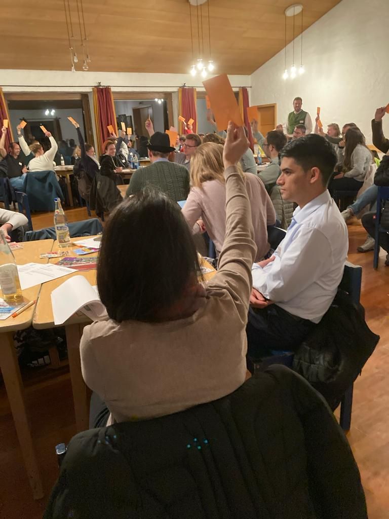 Einzelne Menschen im Saal bei Versammlung