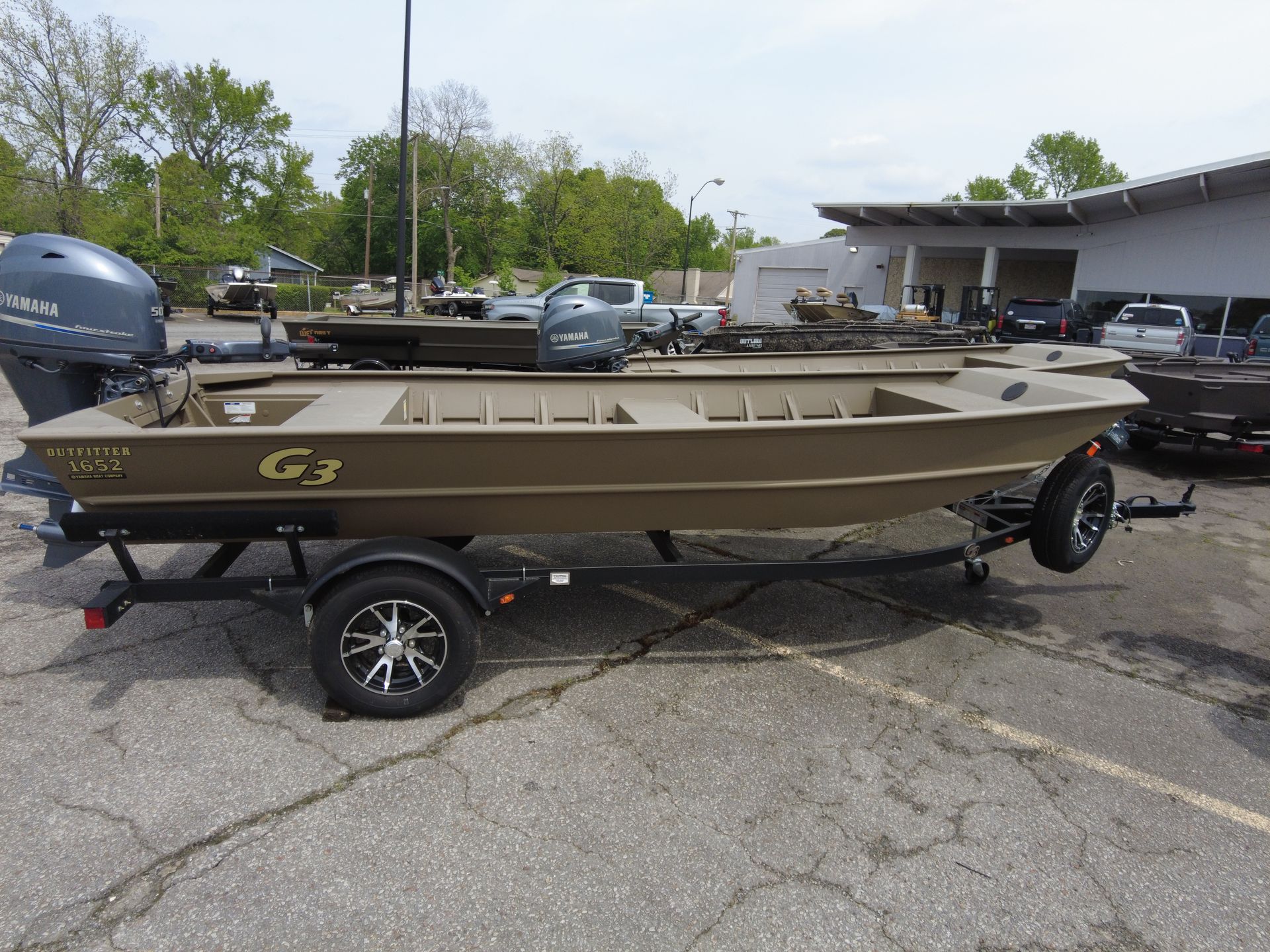 A boat is parked on a trailer in a parking lot.