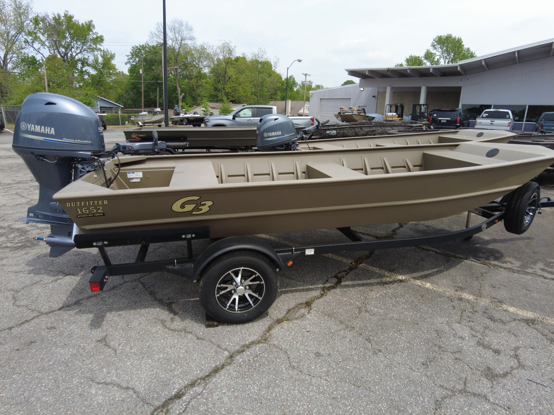 A boat is parked on a trailer in a parking lot.