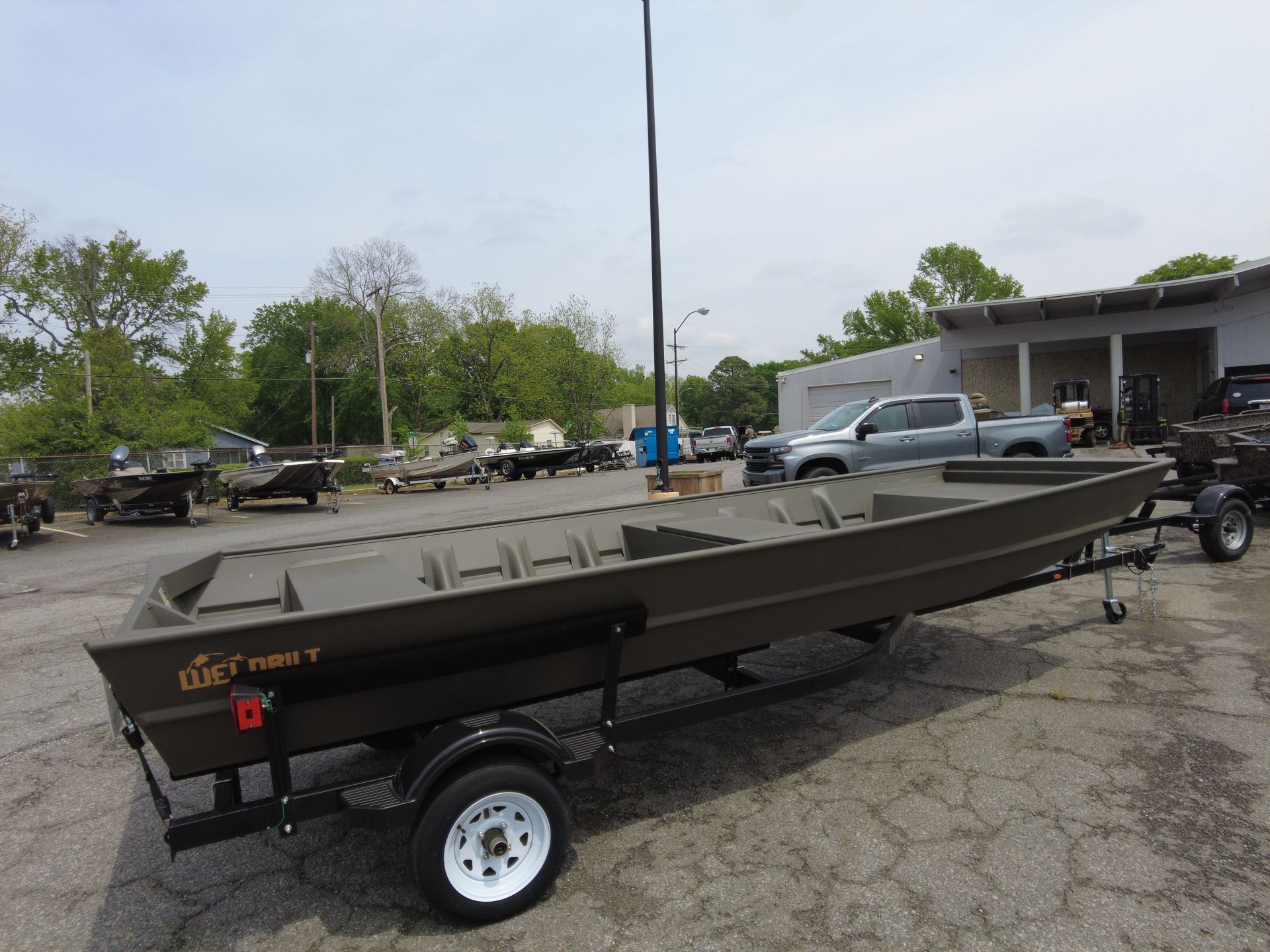 A boat is on a trailer in a parking lot.
