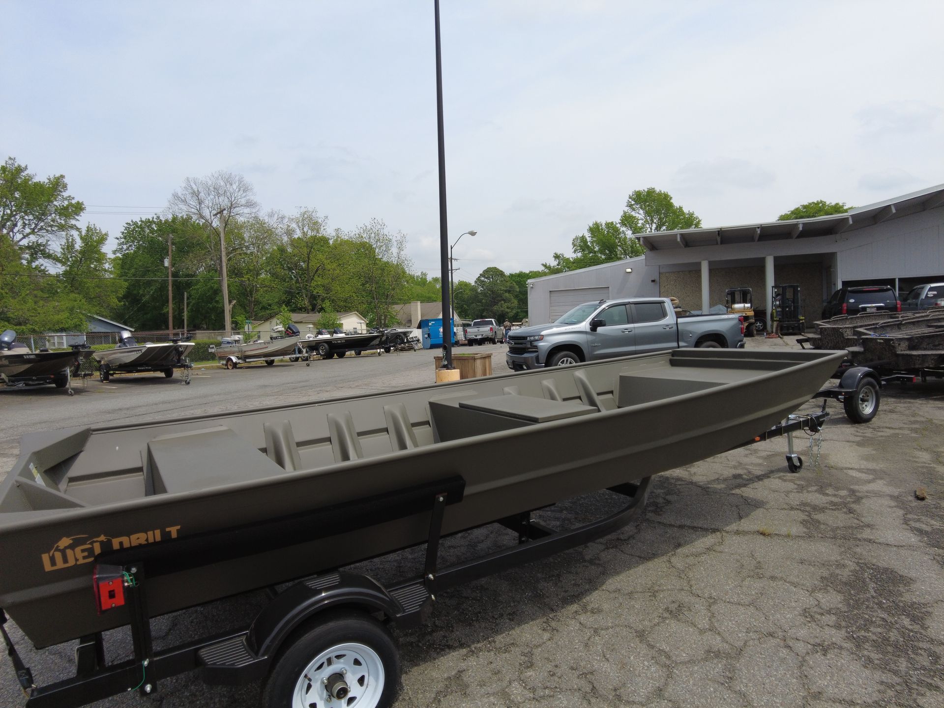 A boat is on a trailer in a parking lot.