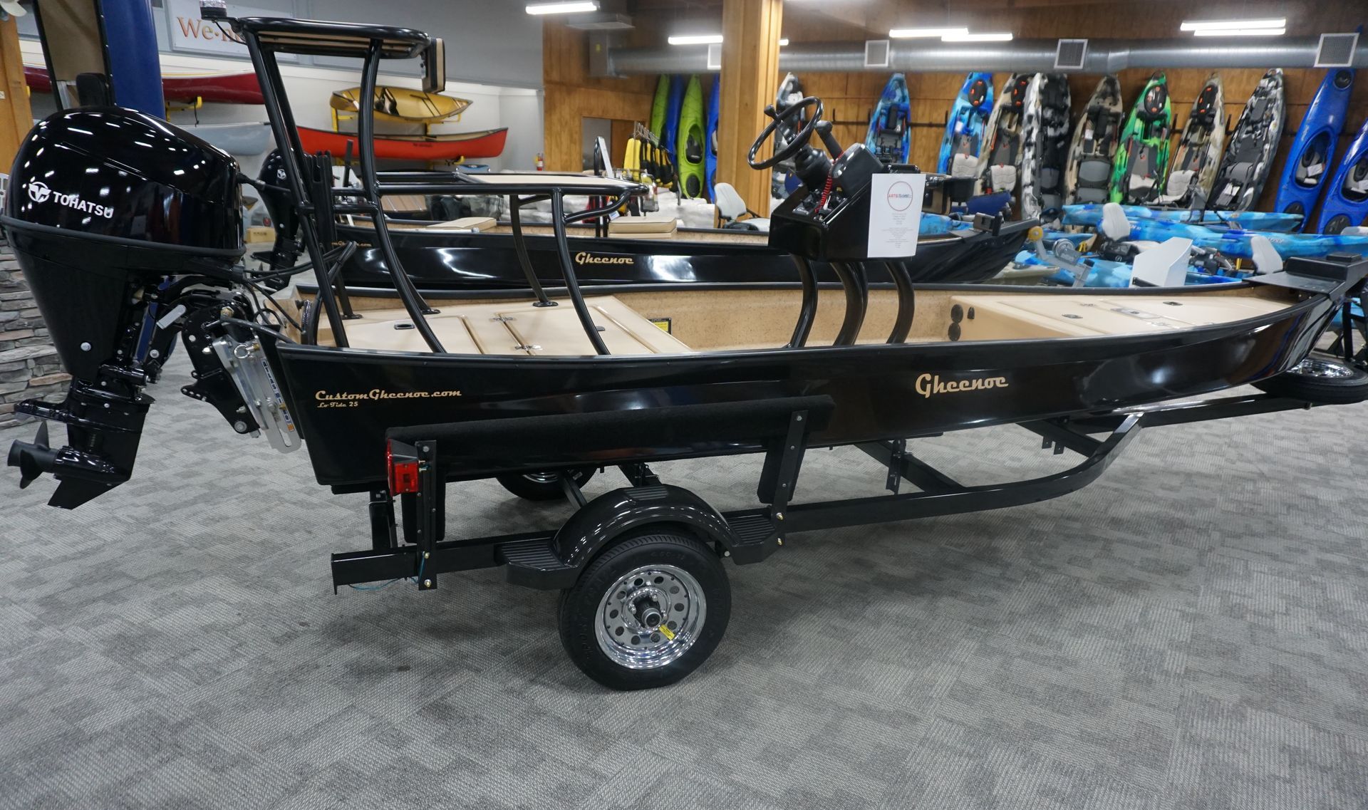 A boat is on display in a showroom with a trailer attached to it.