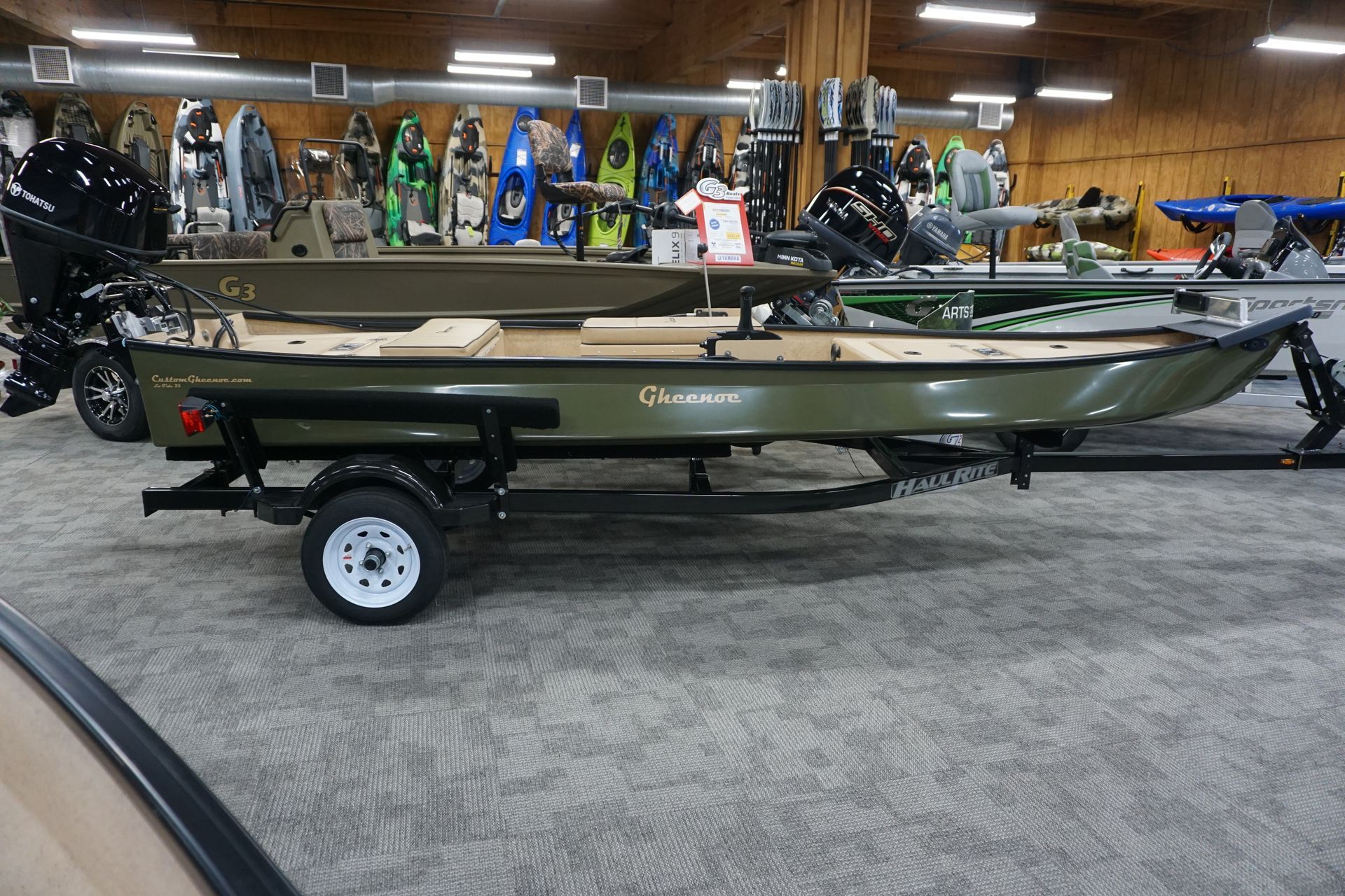 A boat is on a trailer in a showroom.