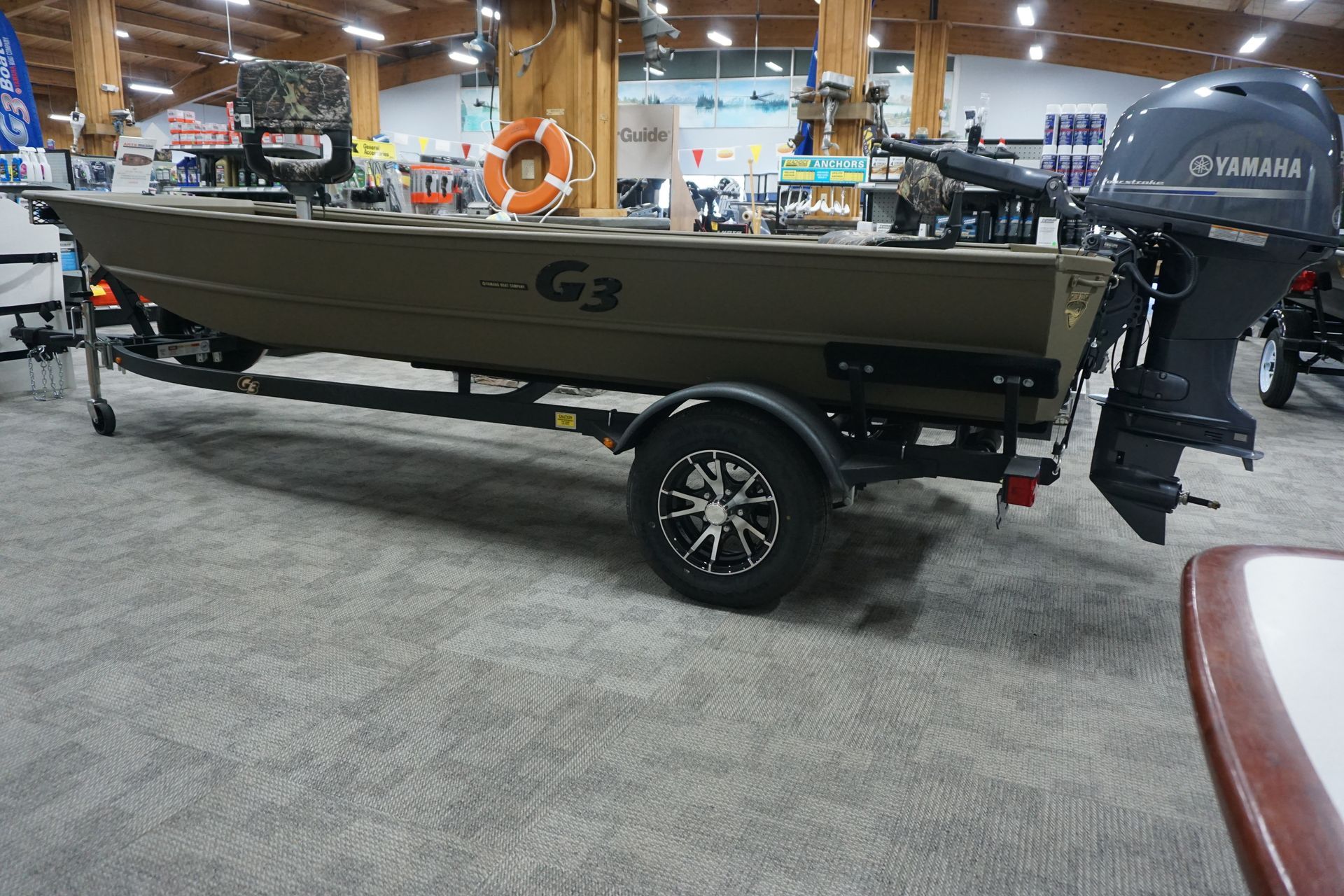 A boat is parked on a trailer in a showroom.