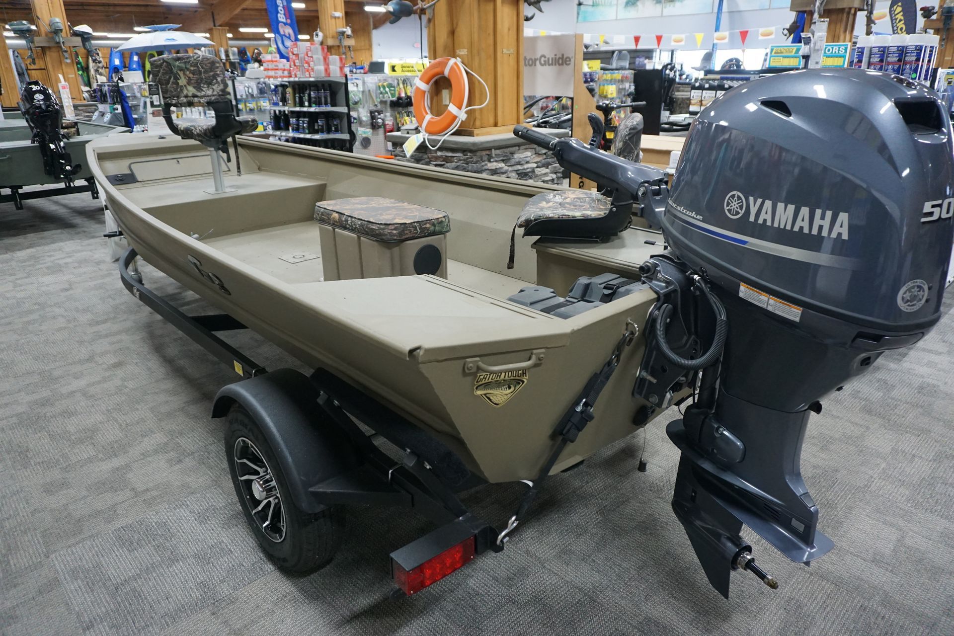 A boat with a yamaha engine is on display in a store.