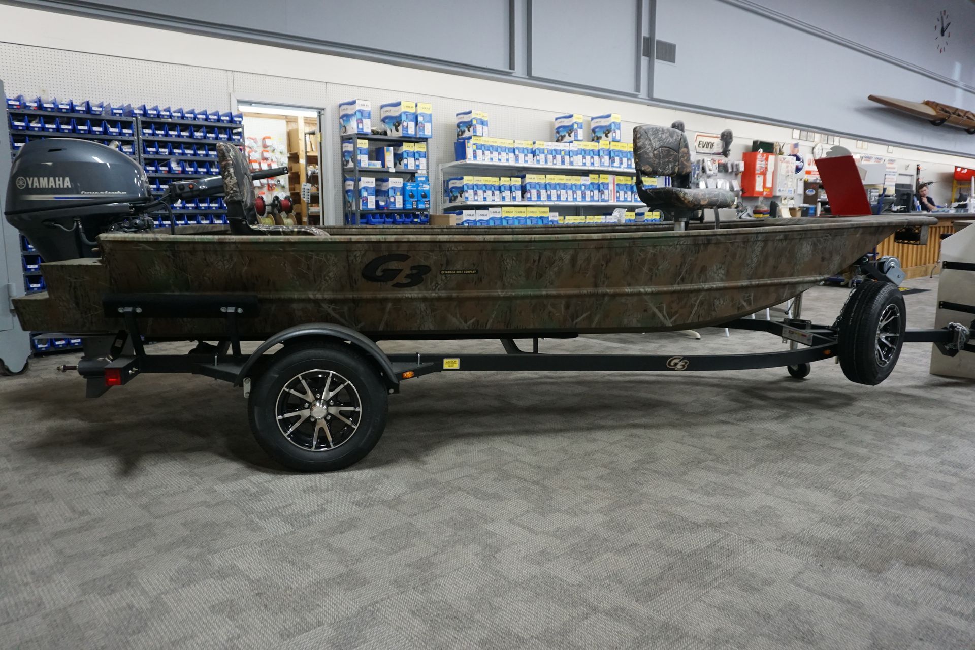 A boat is parked on a trailer in a store.