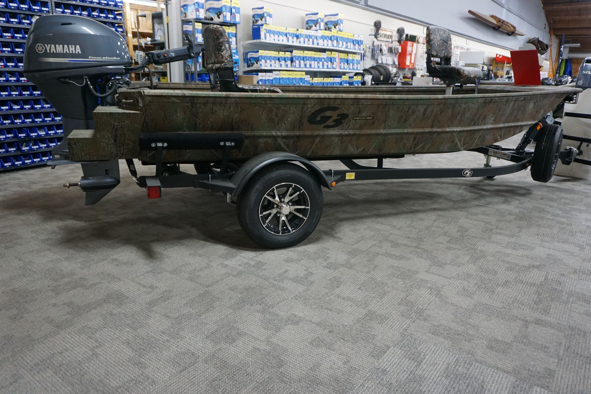 A boat is parked on a trailer in a garage.