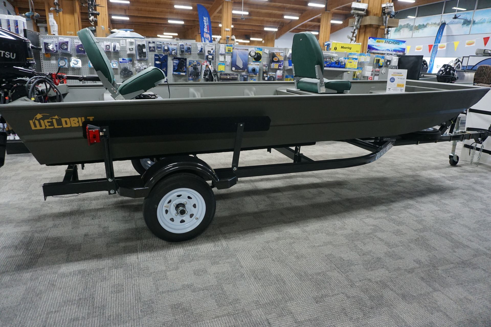 A boat is sitting on a trailer in a store.
