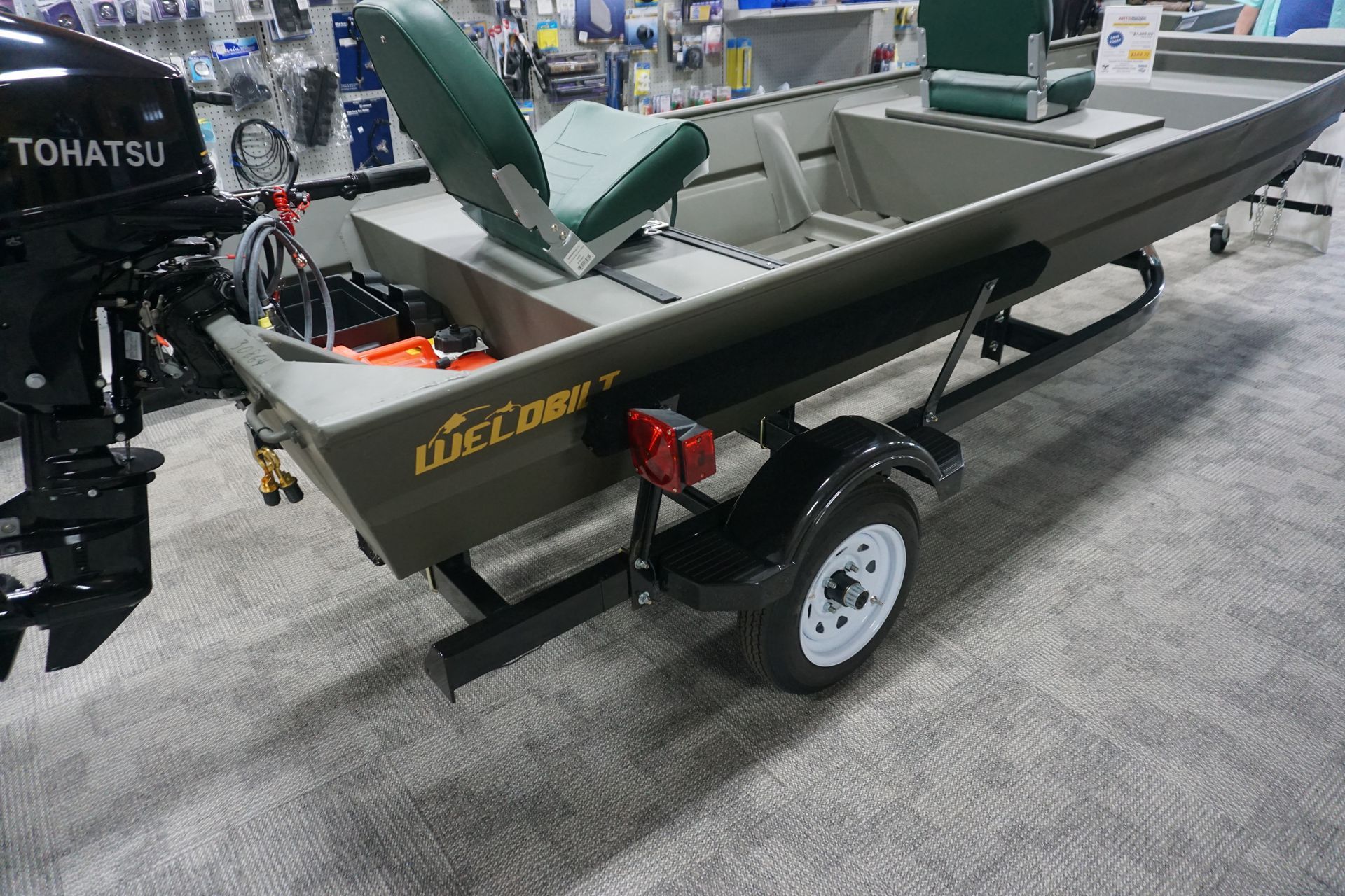 A boat with a trailer attached to it is on display in a store.