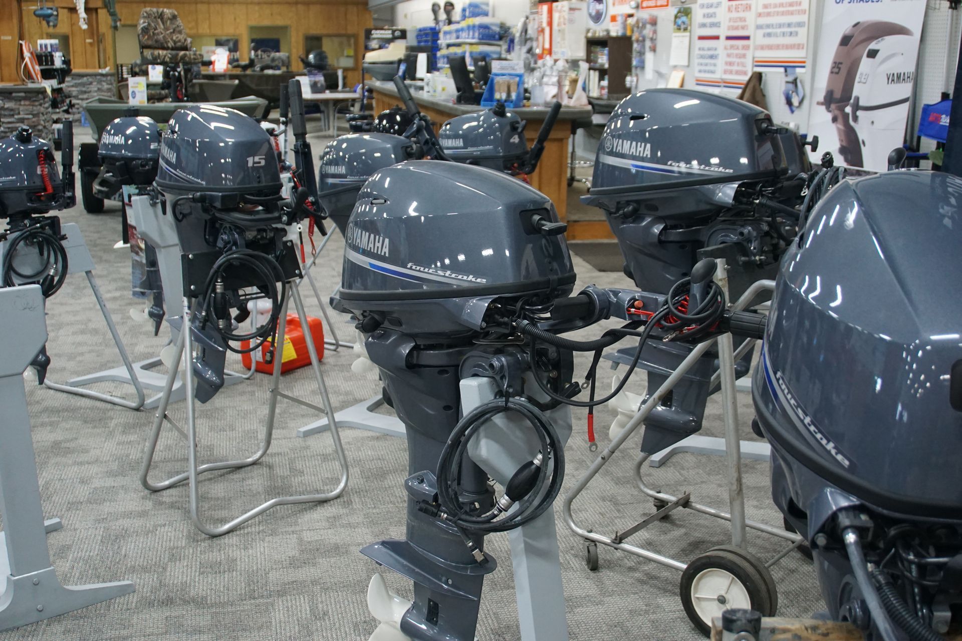 A row of outboard motors are lined up in a showroom.
