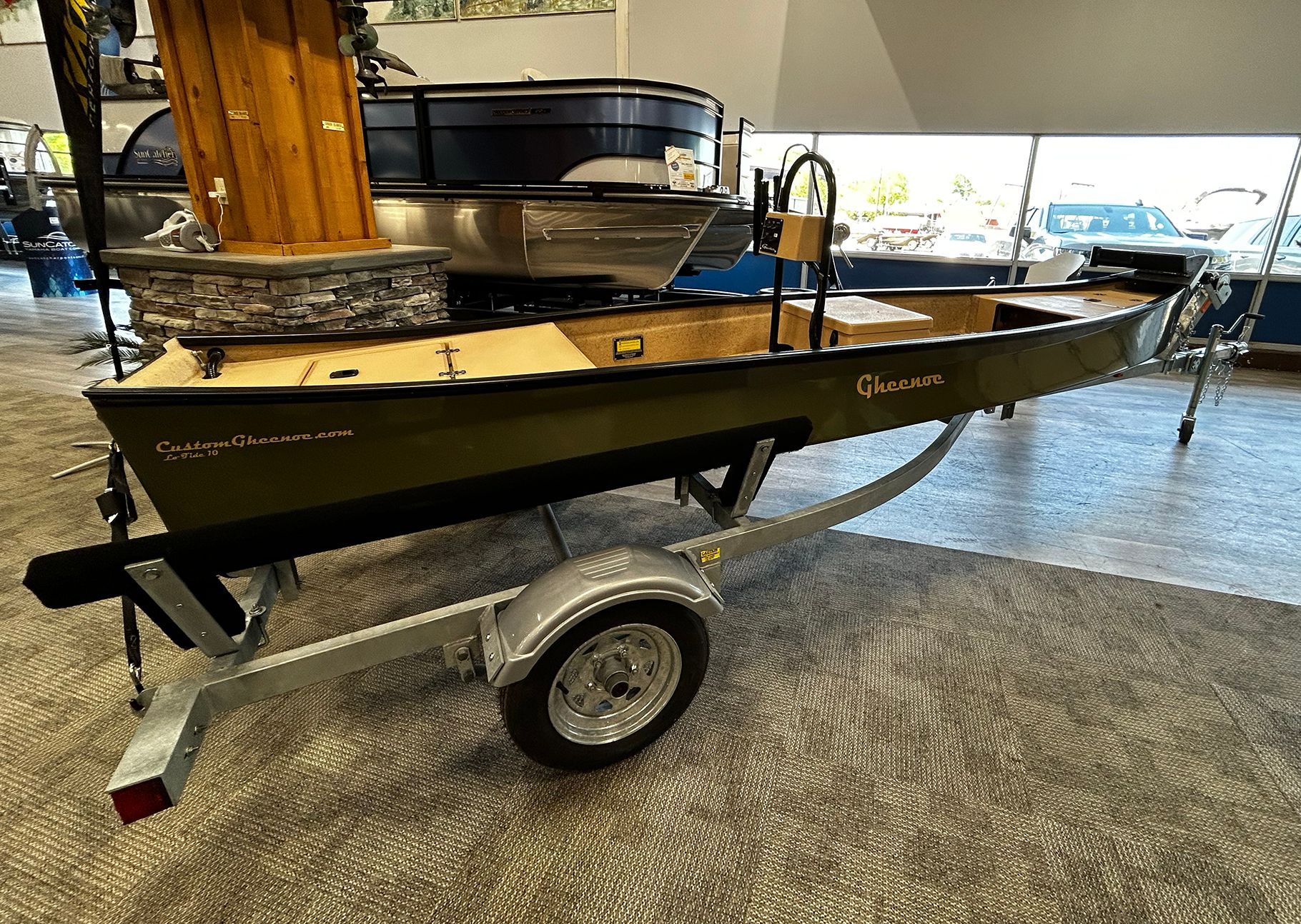A boat is on a trailer in a showroom.