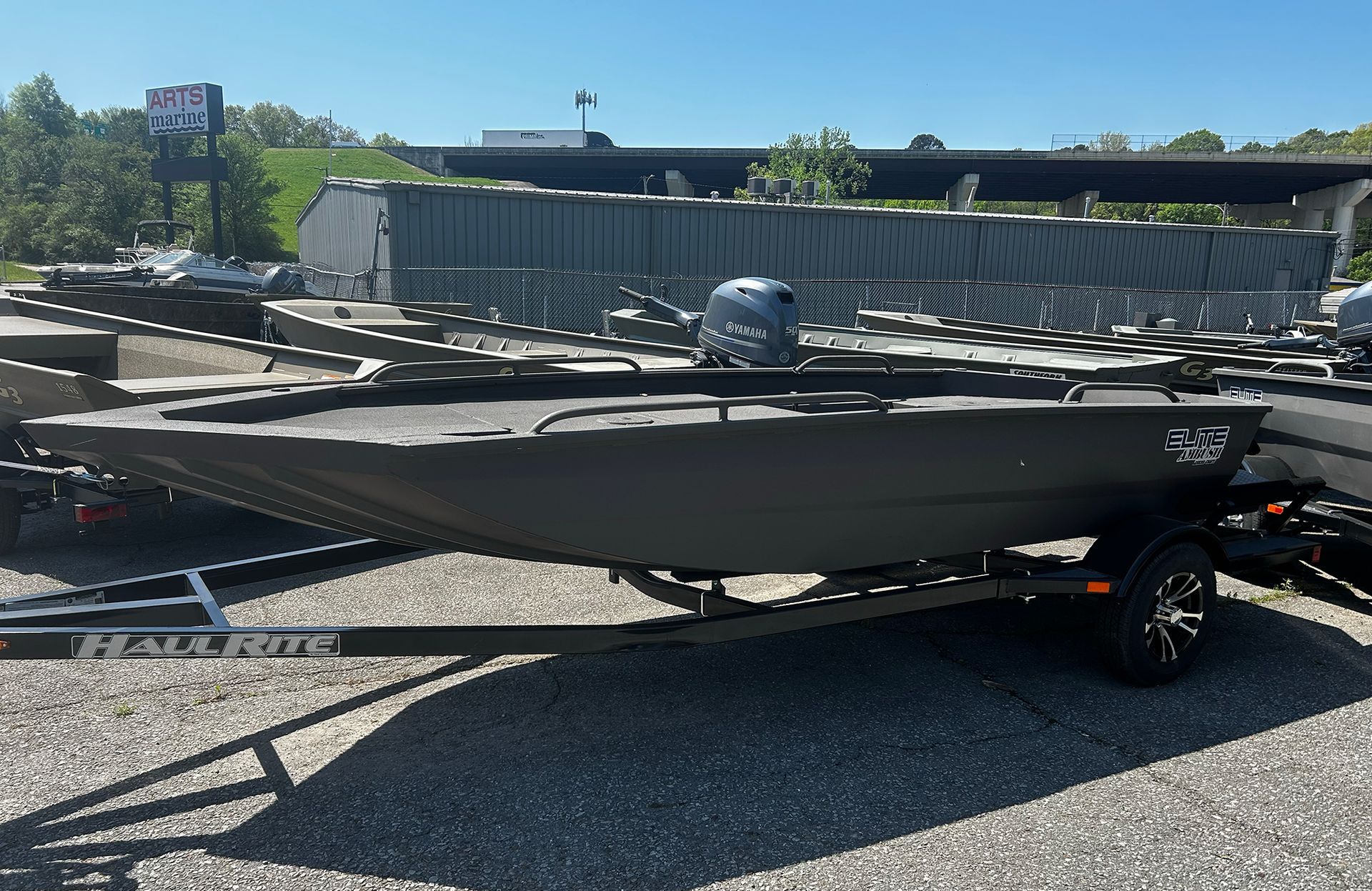 A boat is parked on a trailer in a parking lot.