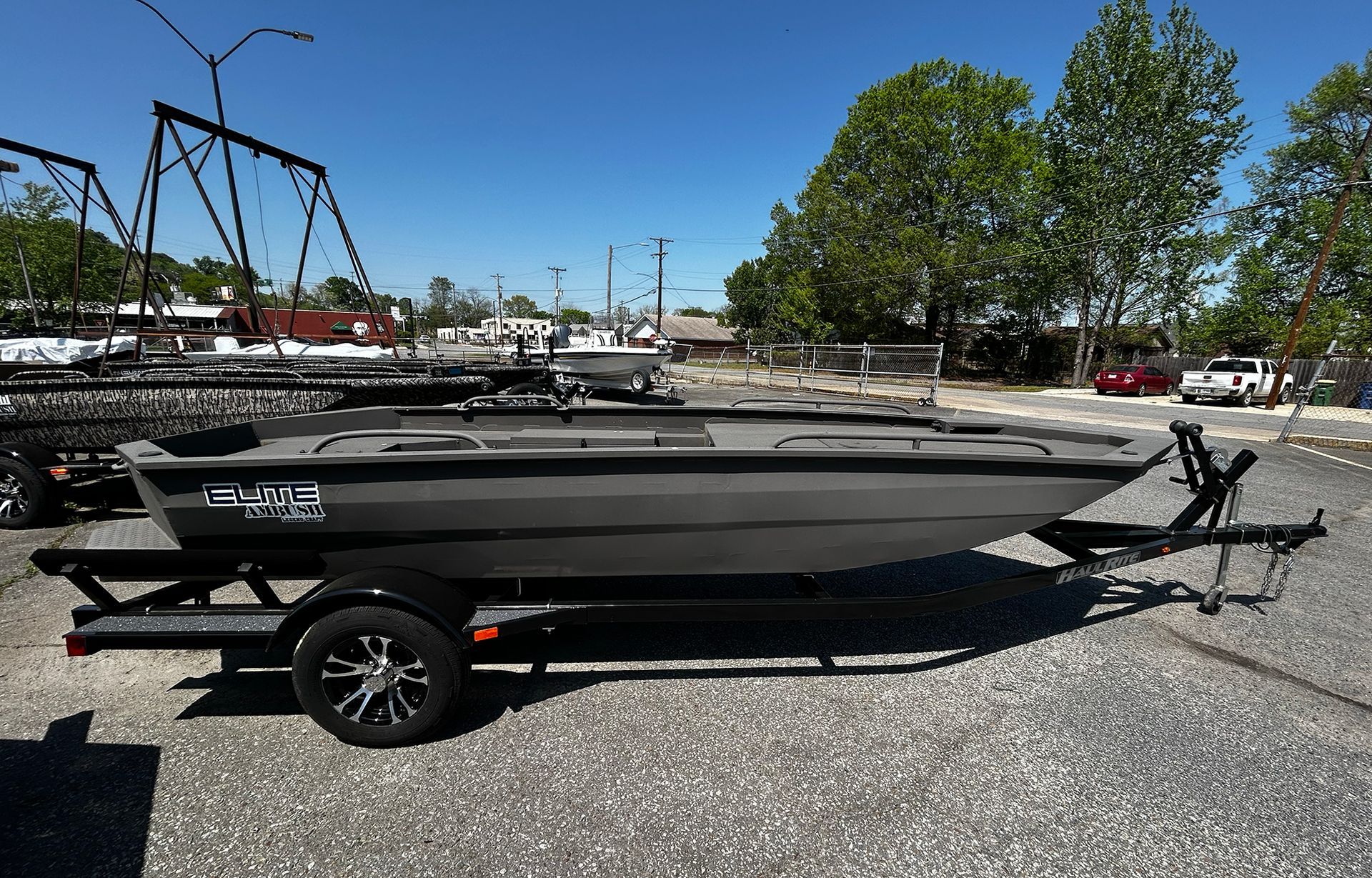A boat is parked on a trailer in a parking lot.