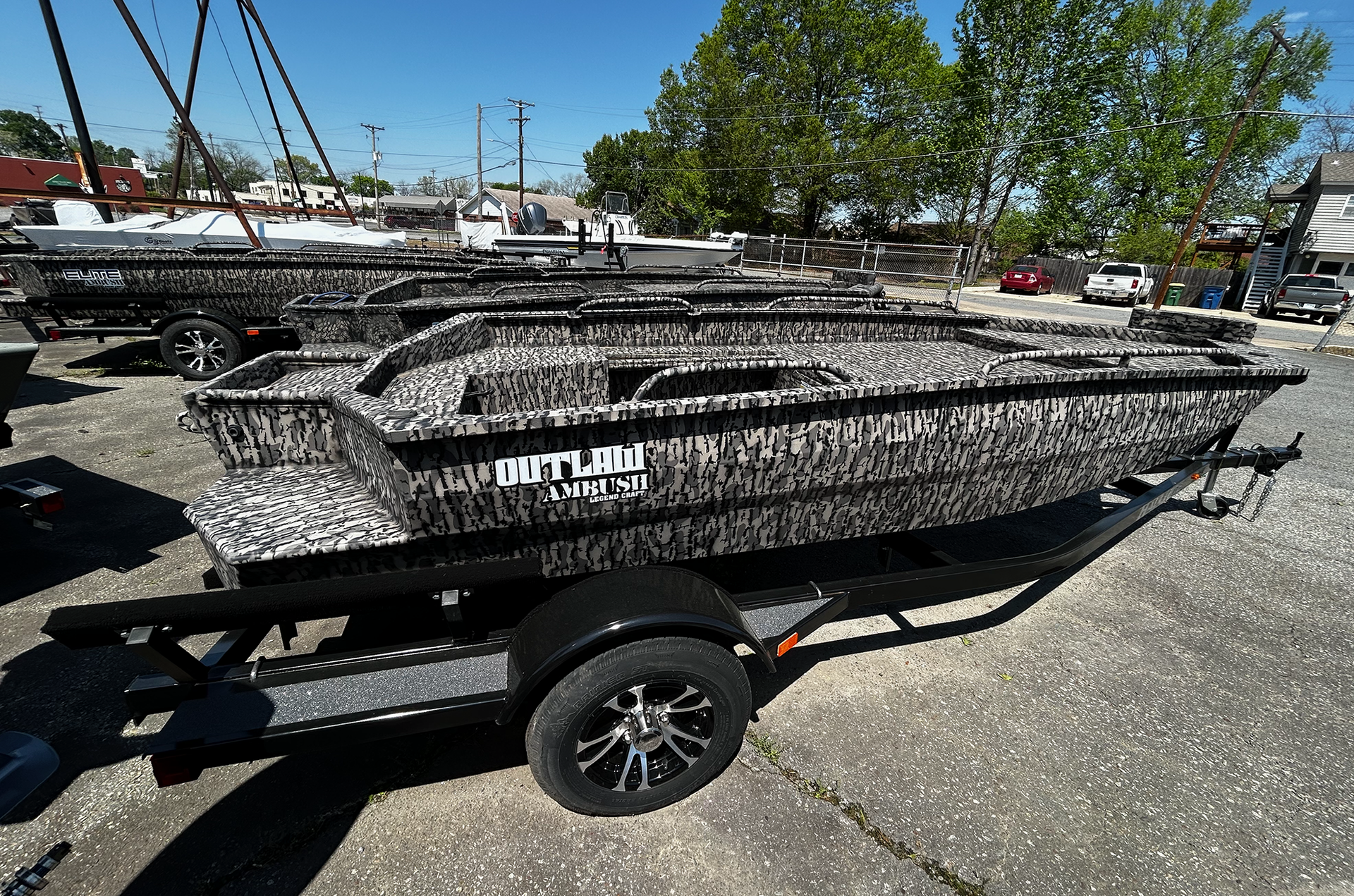 A boat is sitting on a trailer in a parking lot.