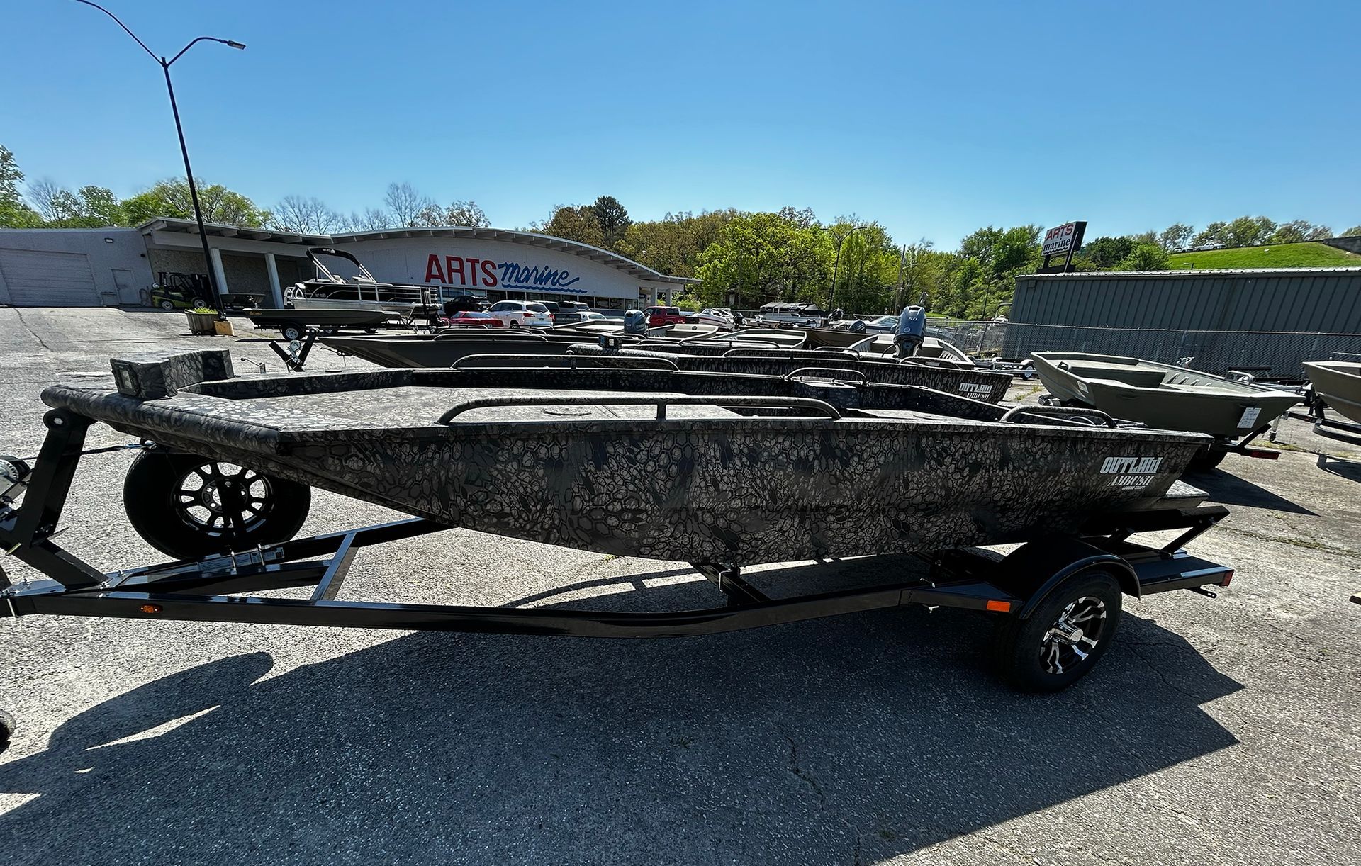 A boat is parked on a trailer in a parking lot.