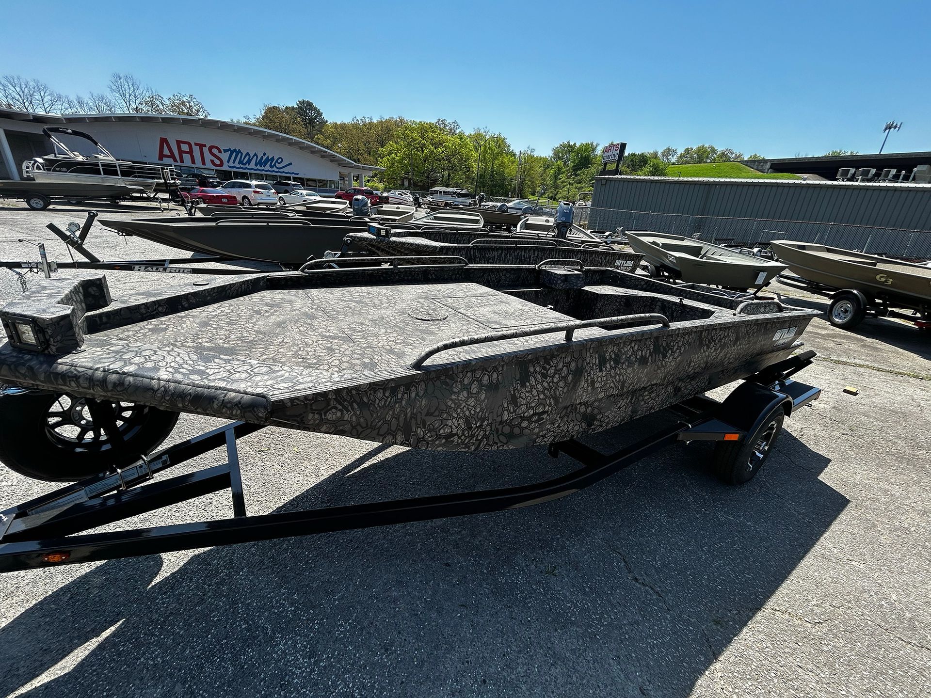 A boat is sitting on a trailer in a parking lot.