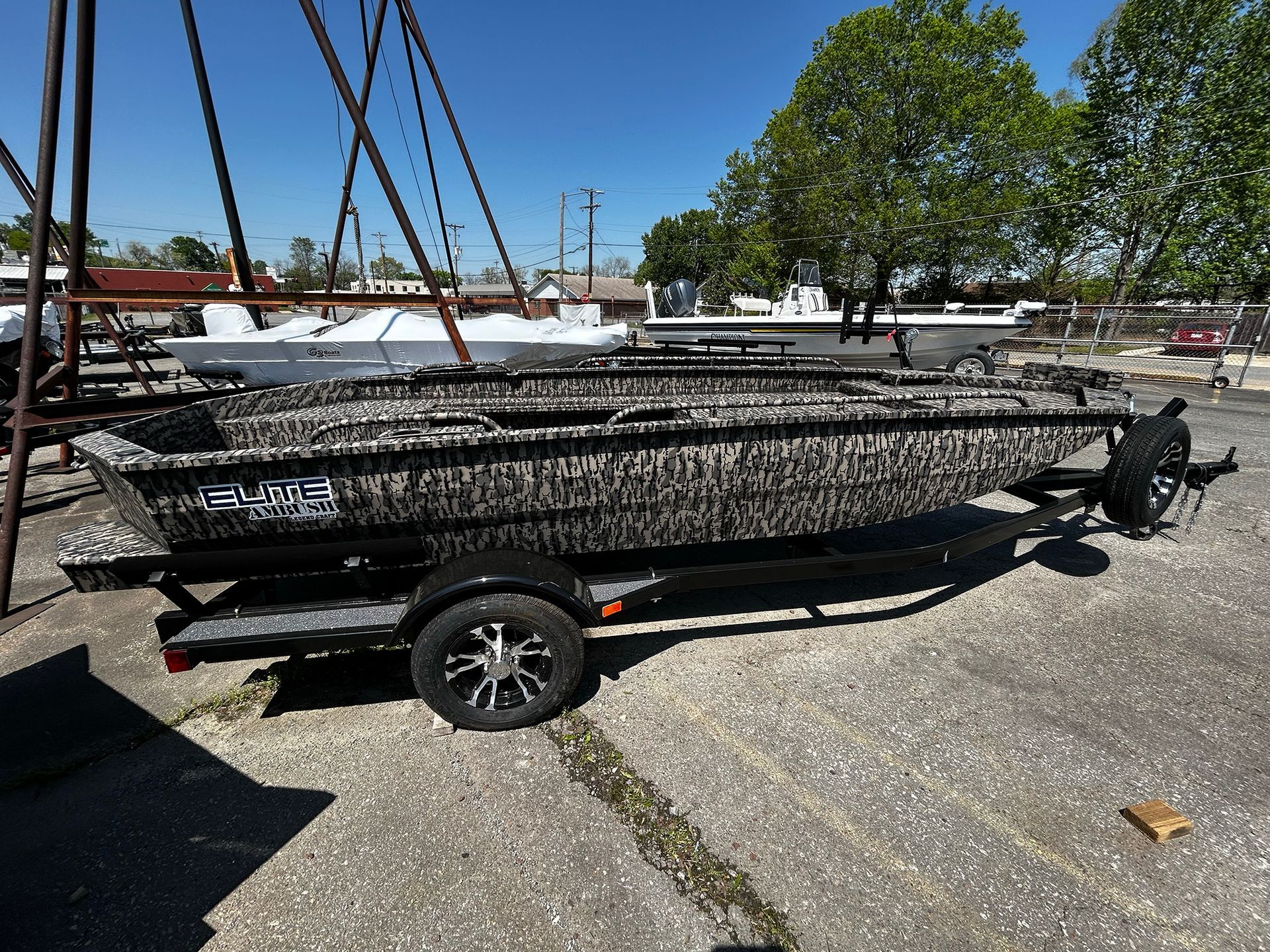 A boat is parked on a trailer in a parking lot.
