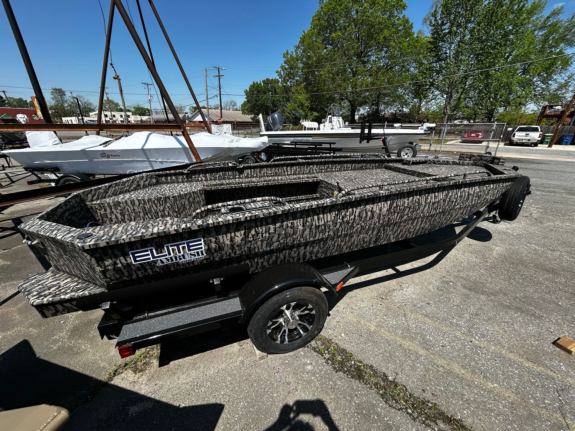 A boat is sitting on a trailer in a parking lot.