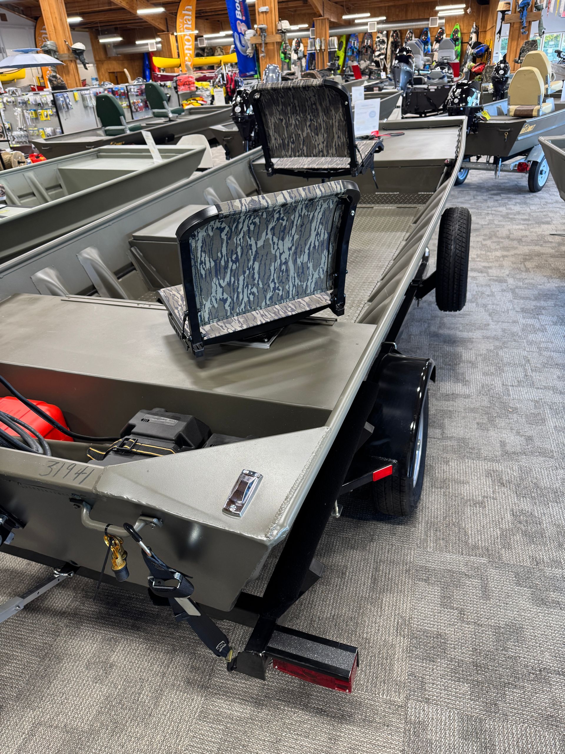Gray fishing boat with two seats on display in a store aisle