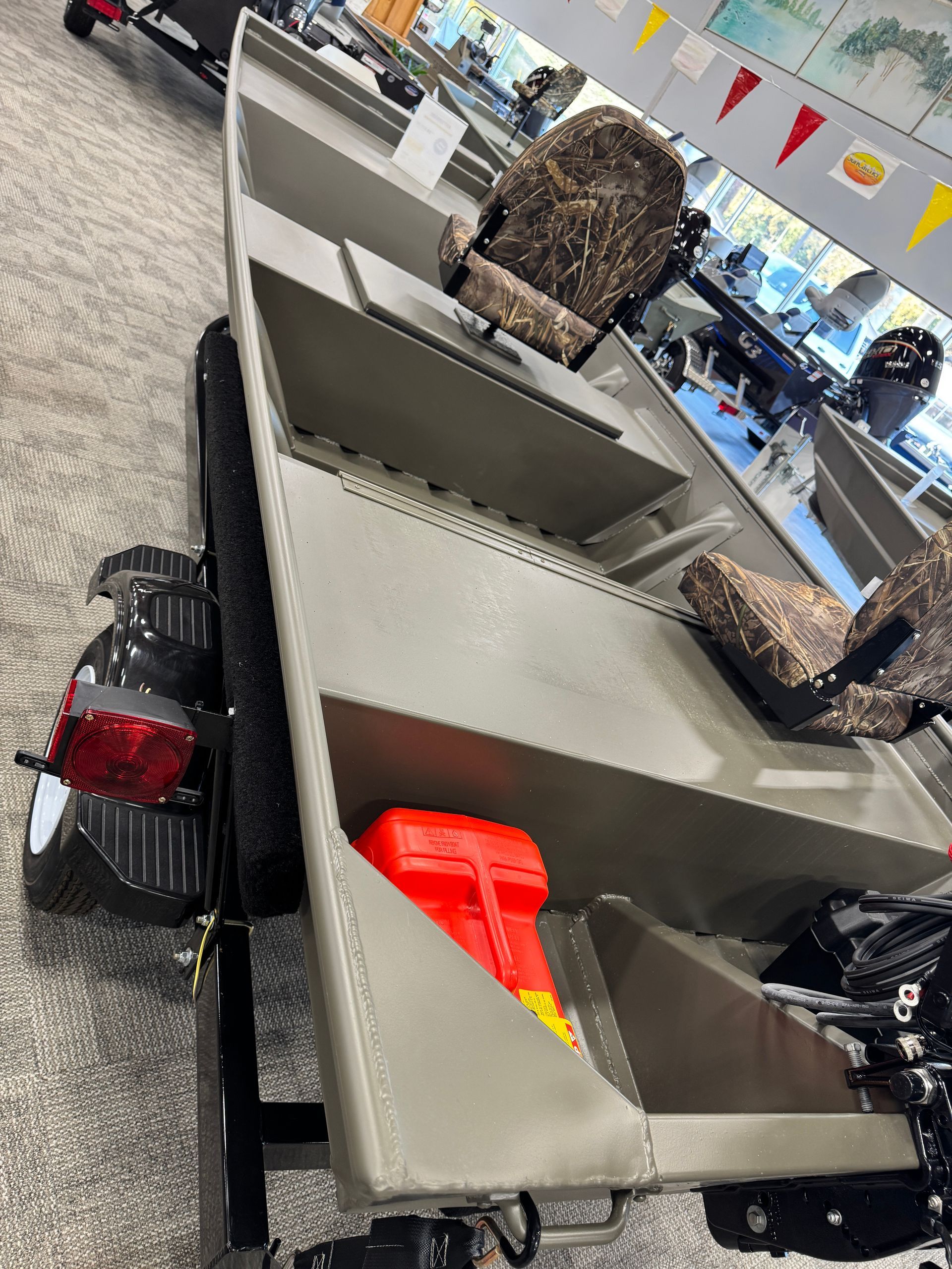 Luggage on an airport baggage carousel, including a red suitcase and camouflage bag.