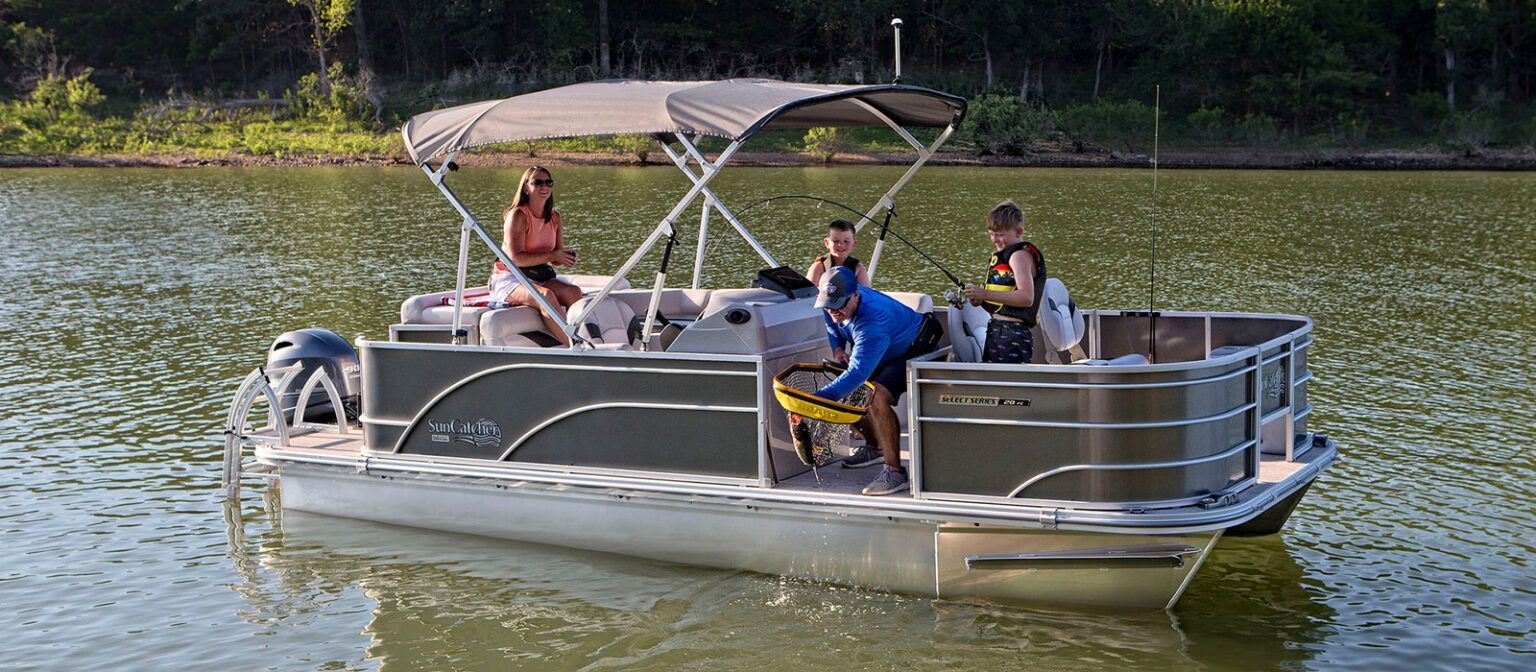 A group of people are riding a pontoon boat on a lake.