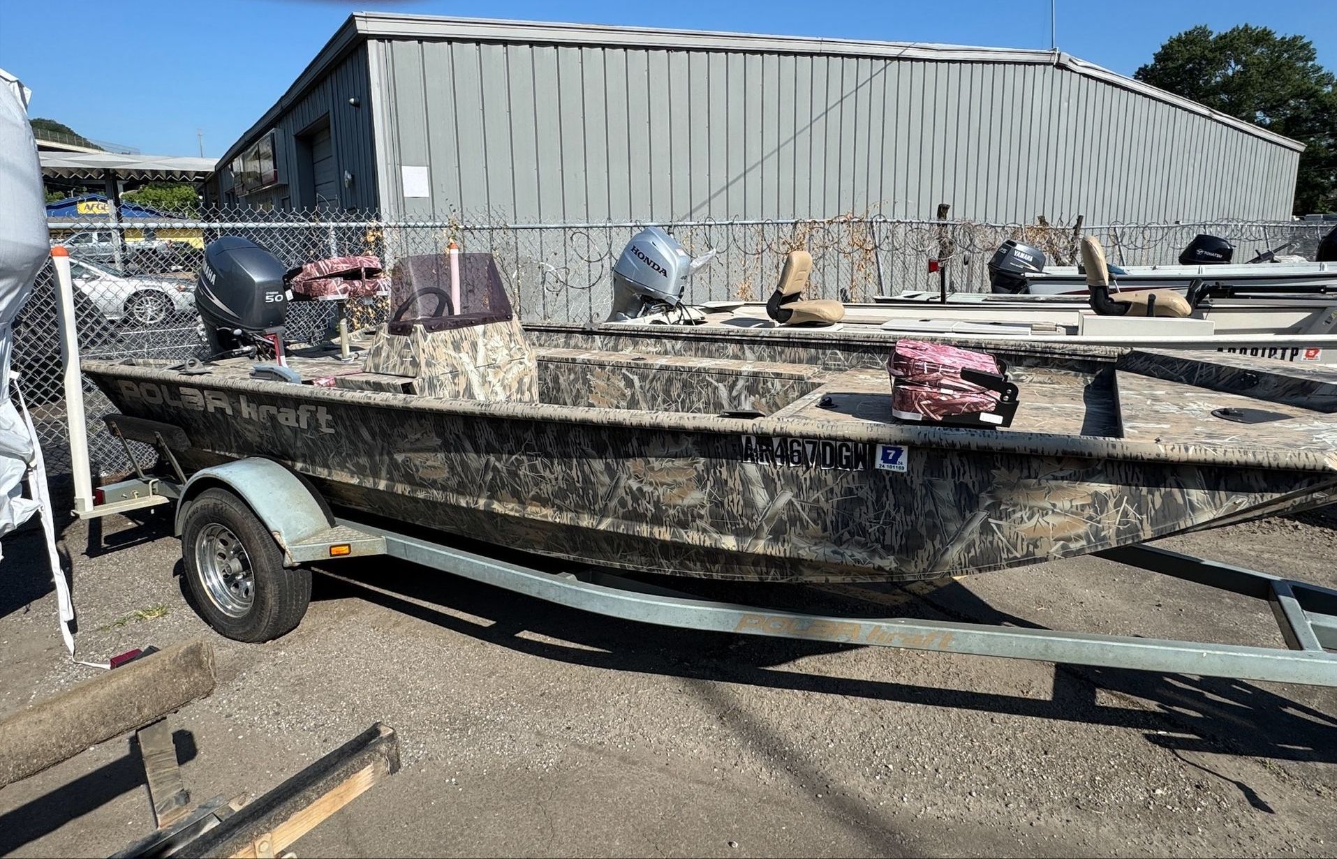 A boat is parked on a trailer in front of a building.