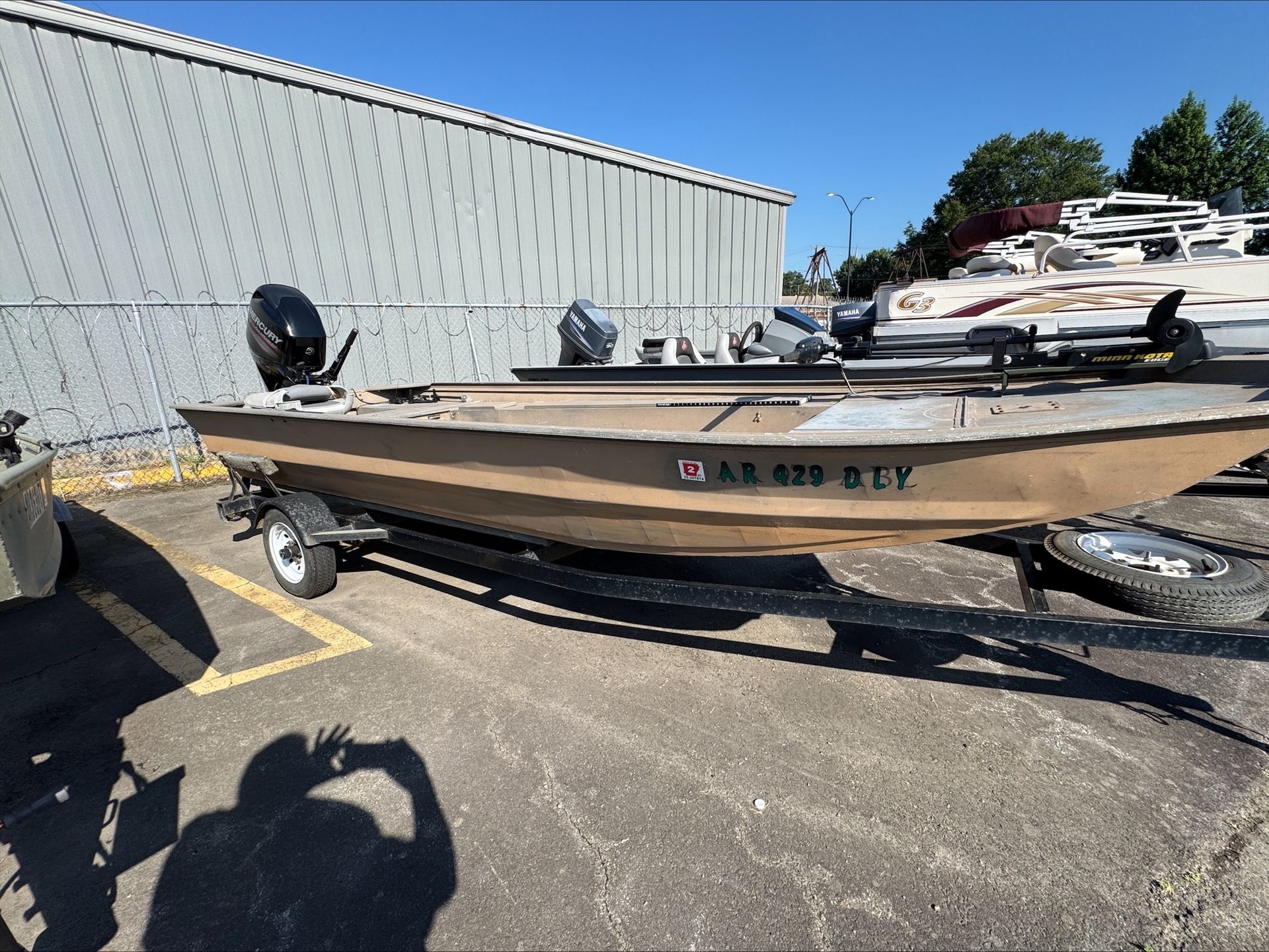 A boat is parked in a parking lot next to a building.