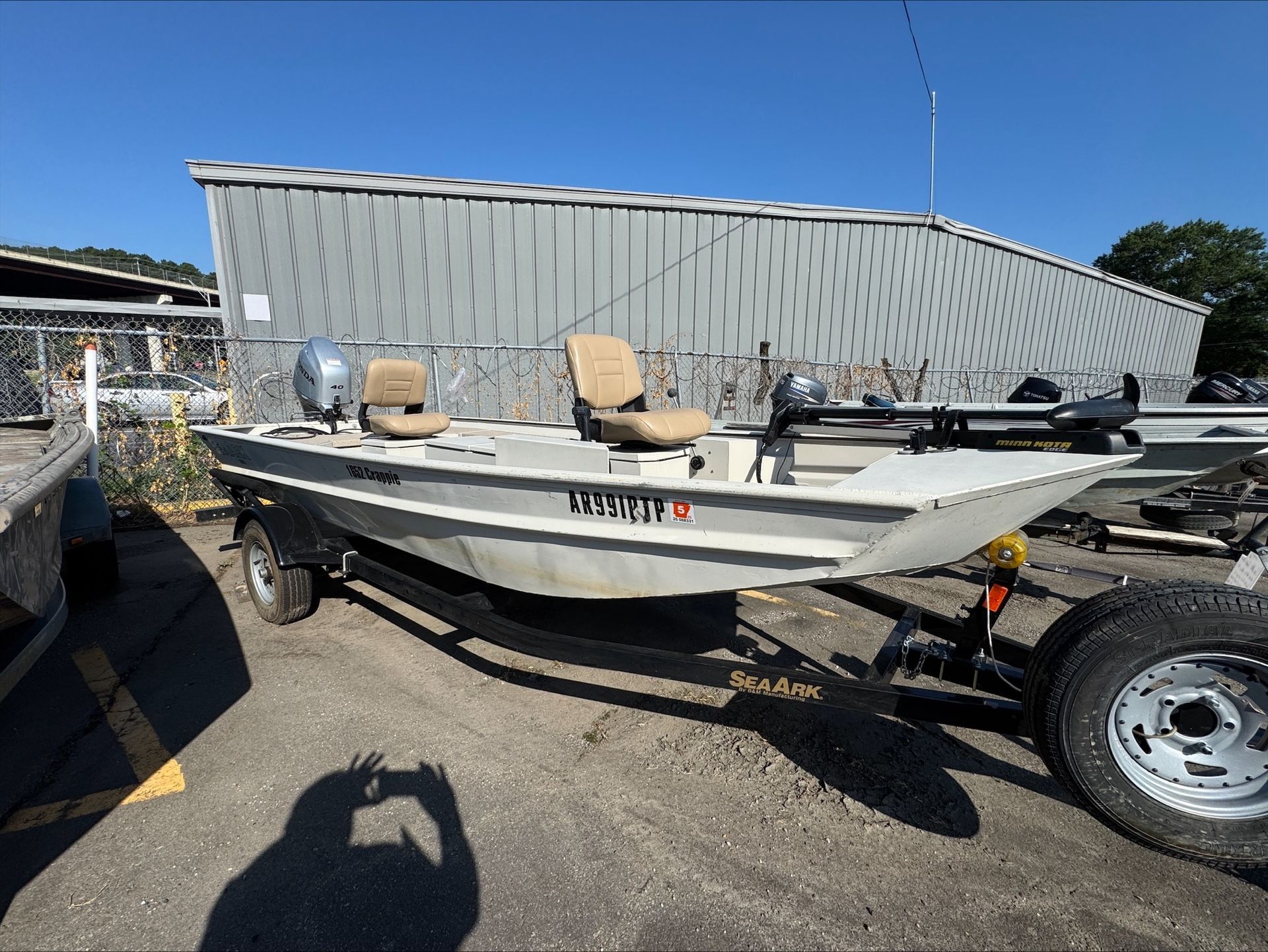 A boat is parked on a trailer in front of a building.