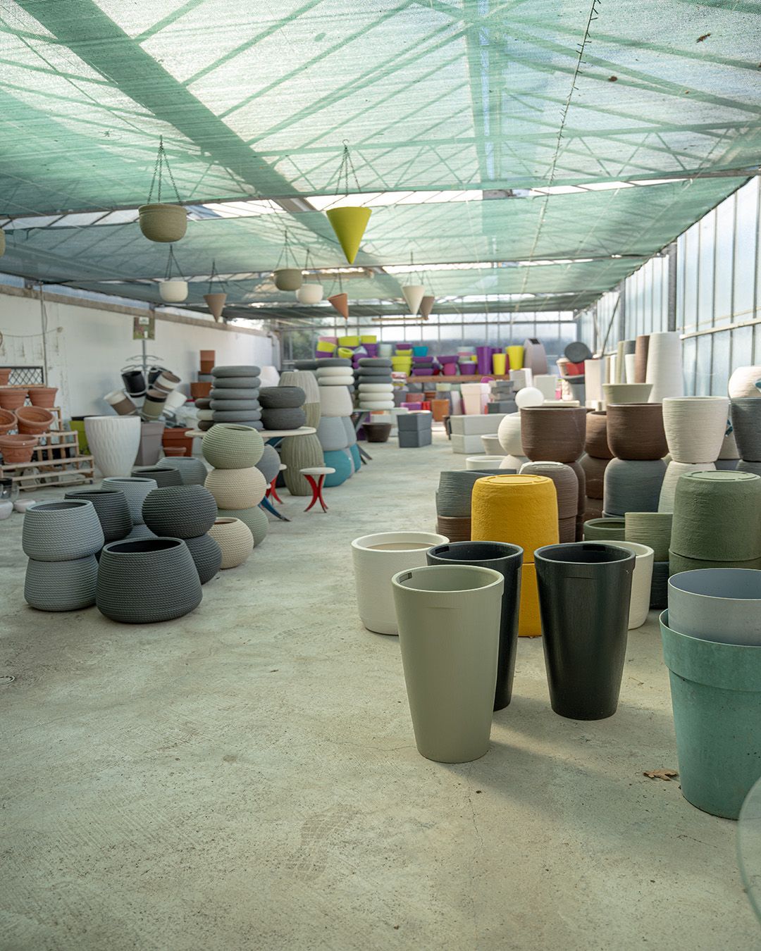 File di fioriere e vasi di ceramica colorati in un laboratorio coperto o in una bancarella del mercato
