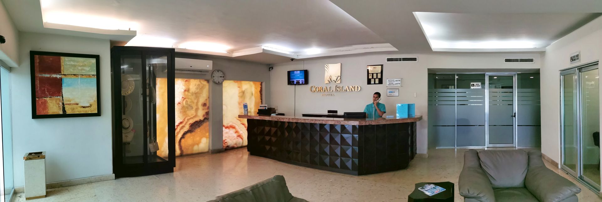 A man is standing at a counter in a hotel lobby.