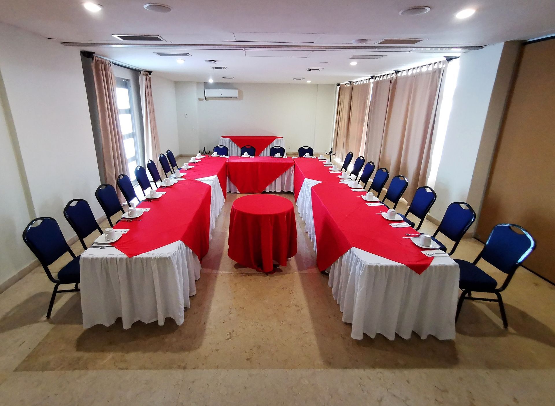 A large room with tables and chairs set up for a meeting