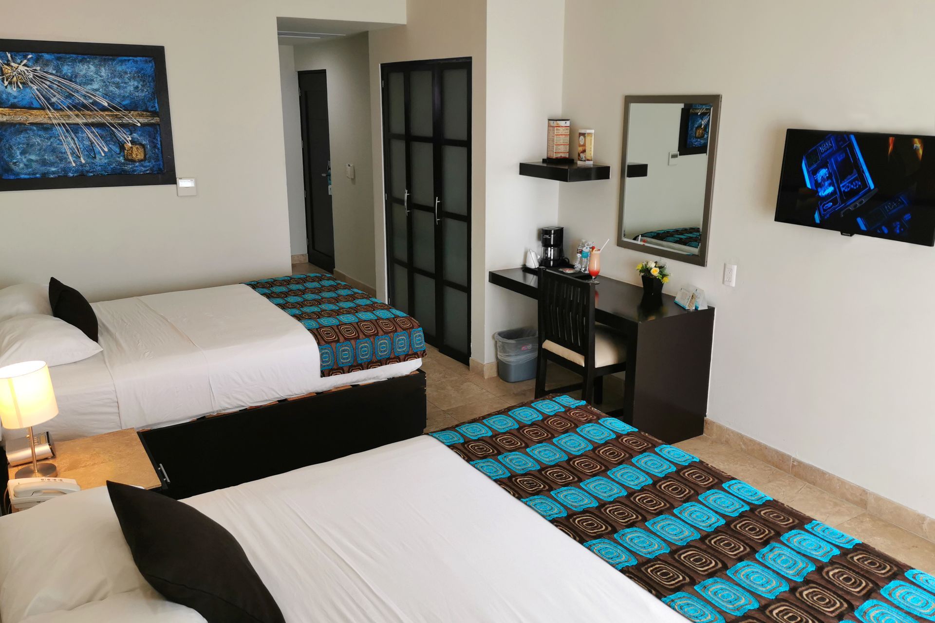 A hotel room with two beds , a desk and a television.