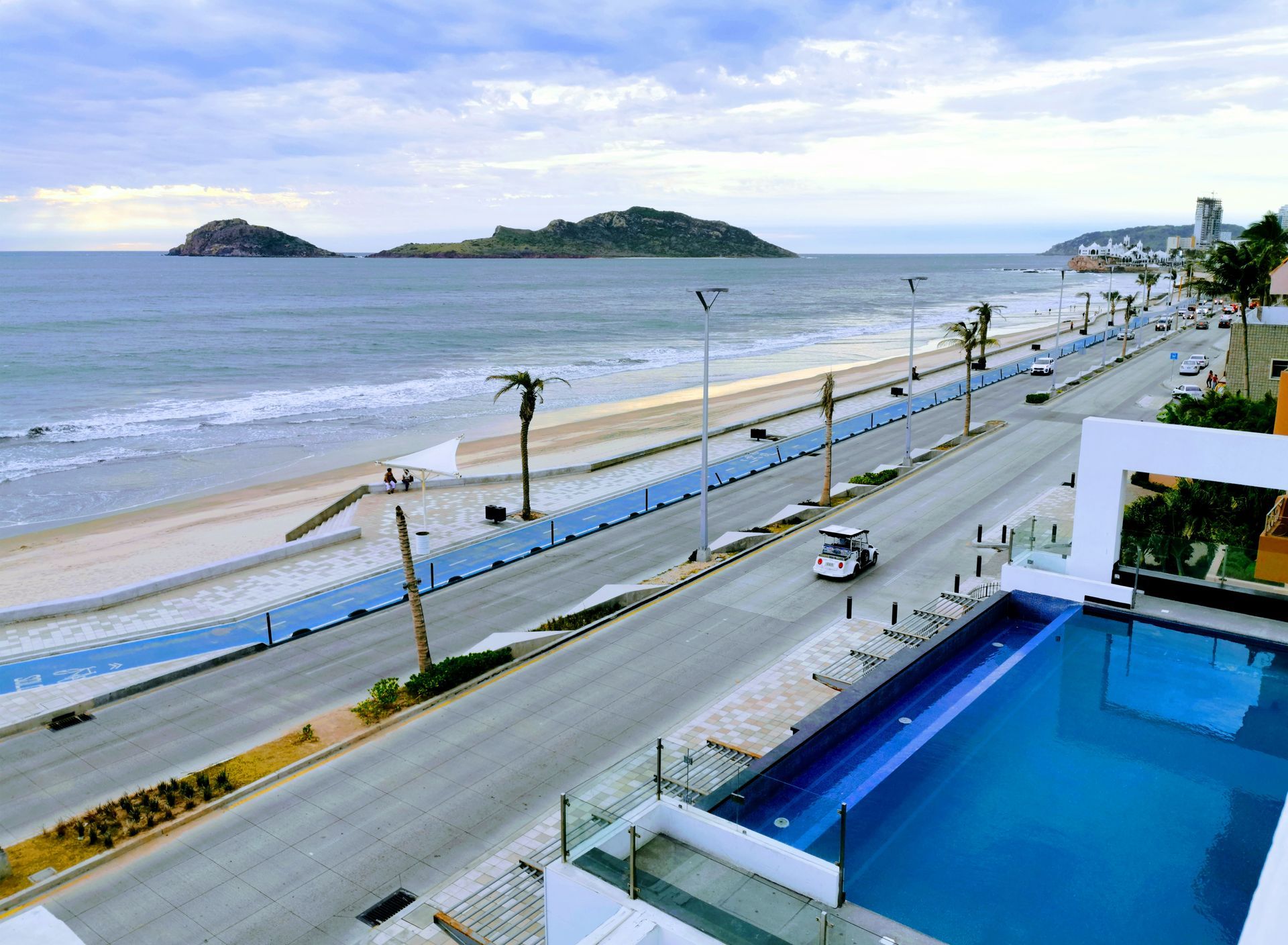 Una vista aérea de una playa con una piscina en primer plano.