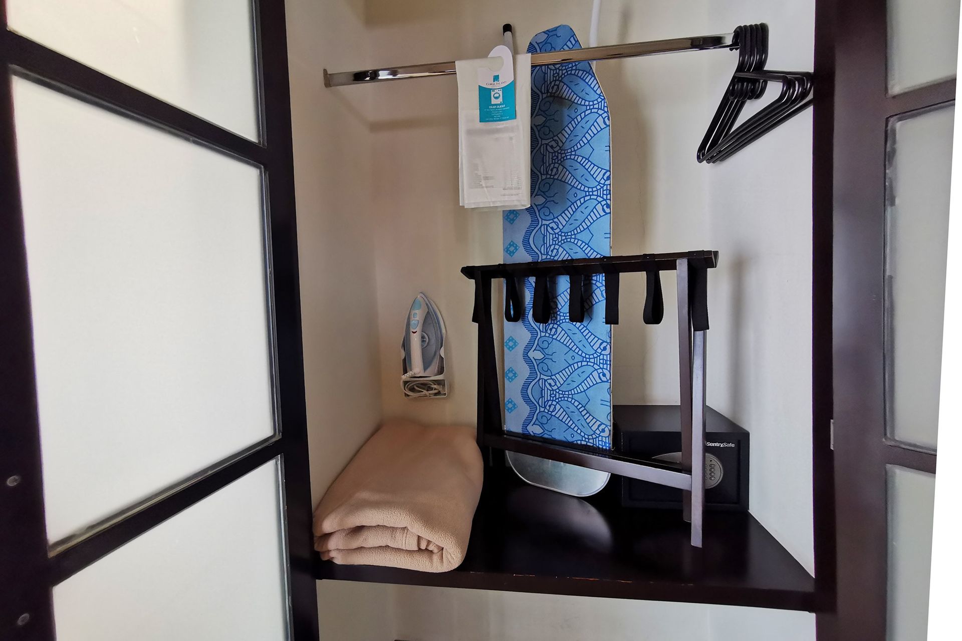 Un armario con una tabla de planchar y una manta en un estante en hotel en mazatlan
