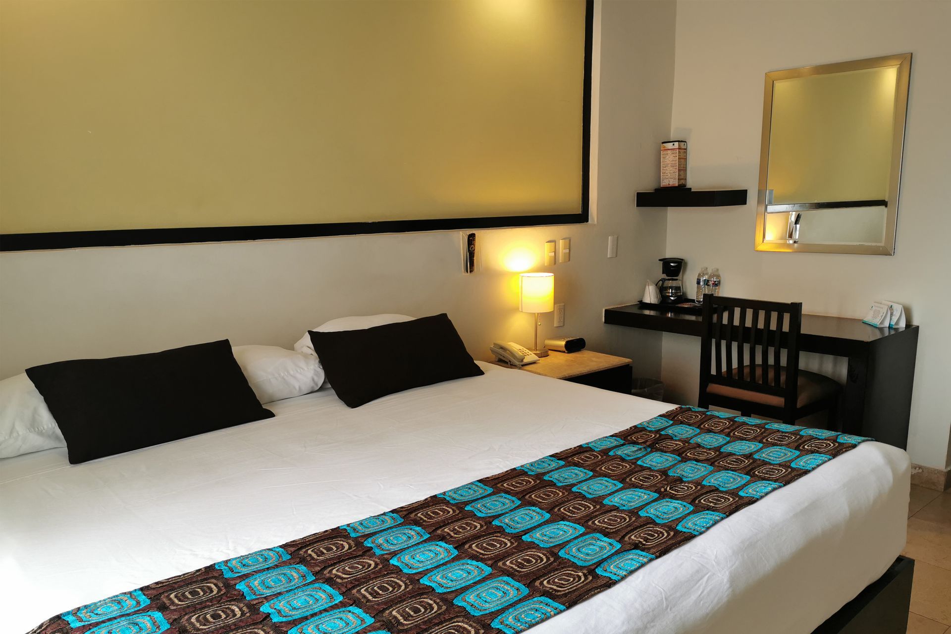 A hotel room with a king size bed and a desk