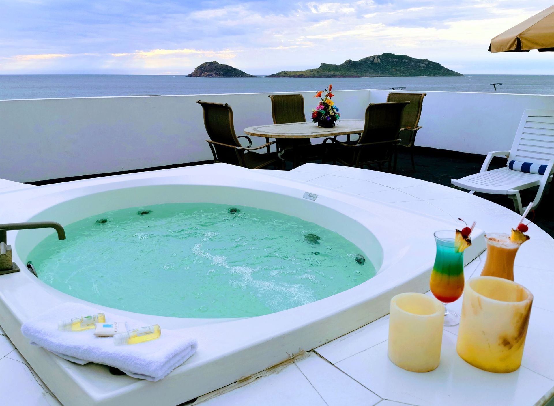 A jacuzzi on a balcony overlooking the ocean