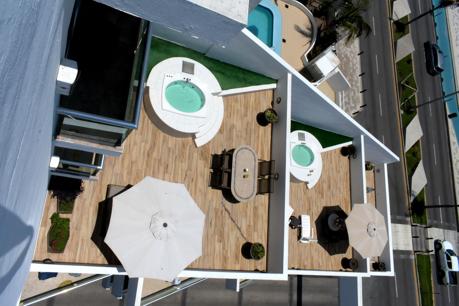An aerial view of a building with a pool and umbrellas