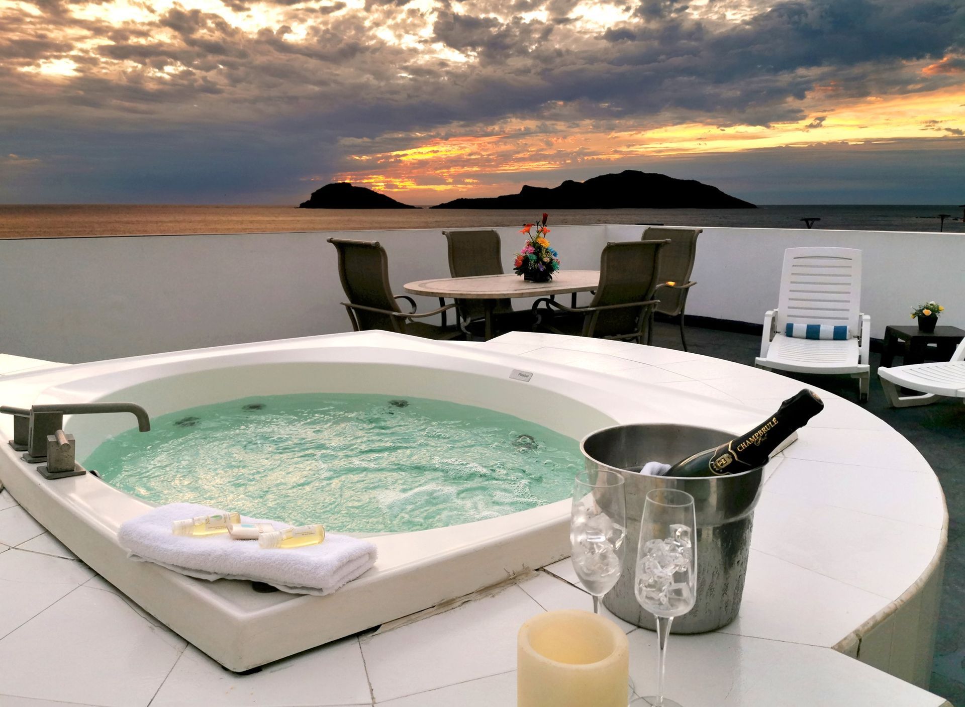 A jacuzzi with a bucket of champagne and a candle