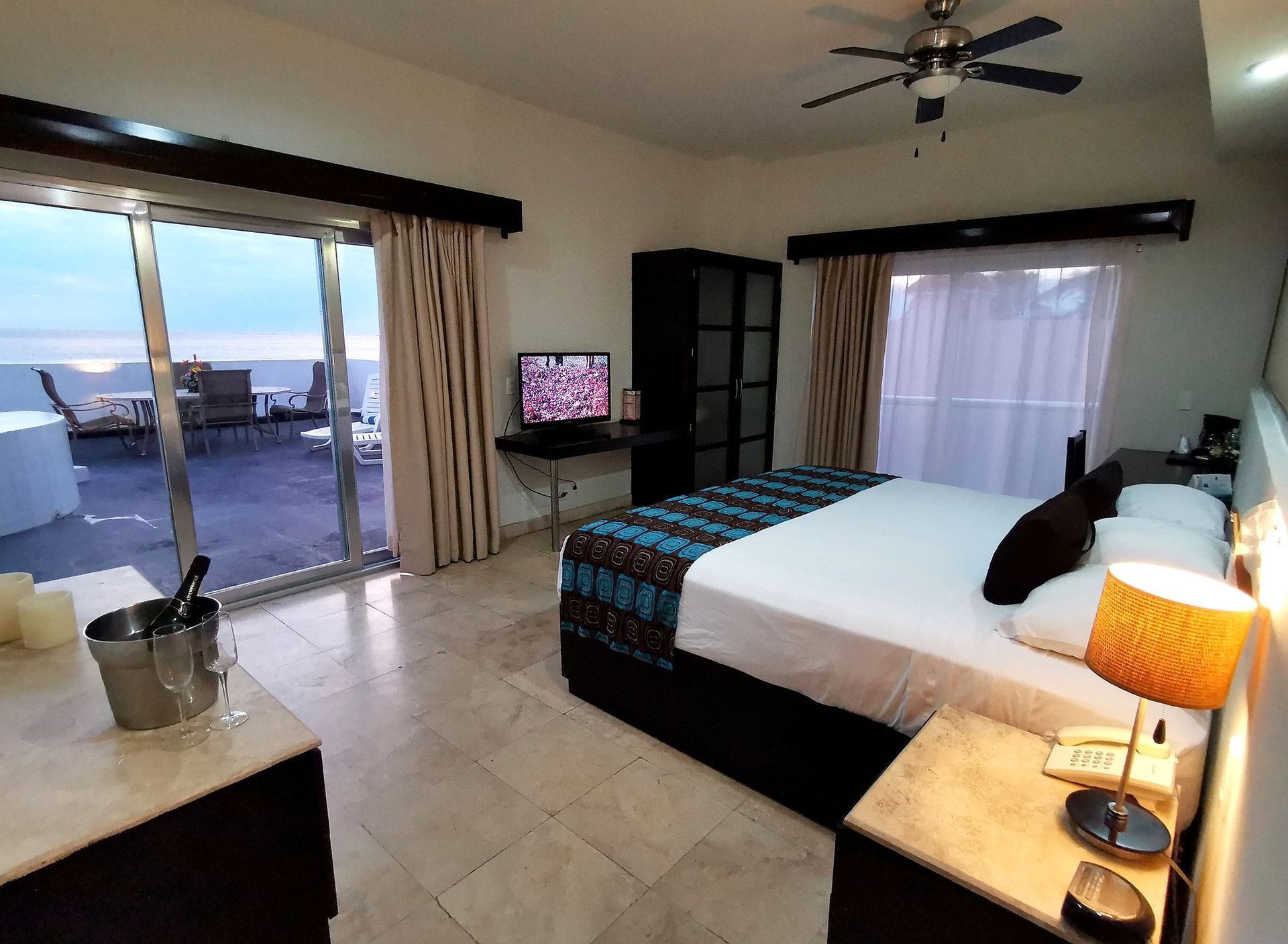 A hotel room with a king size bed and a television