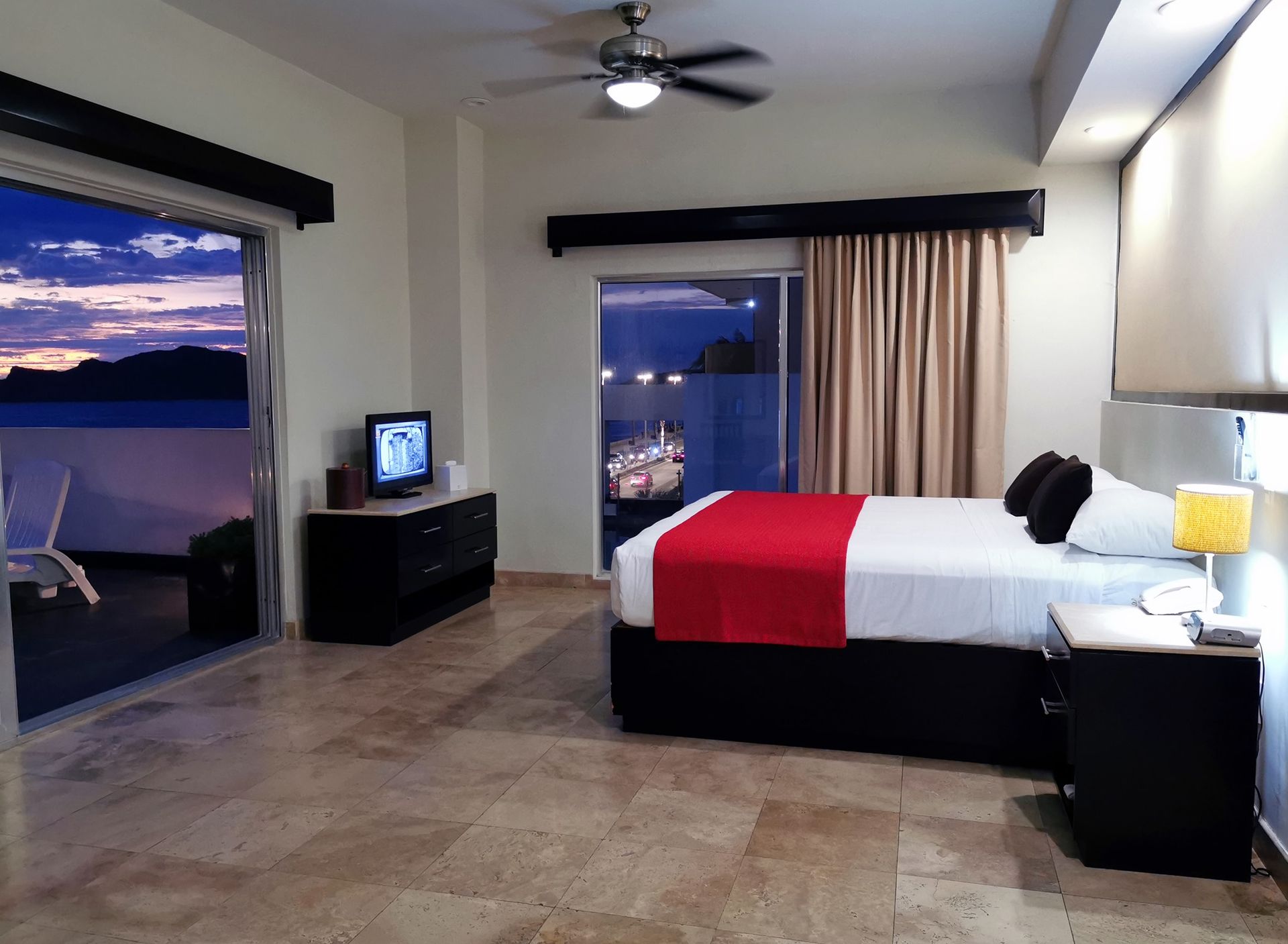 A hotel room with a large bed and a television