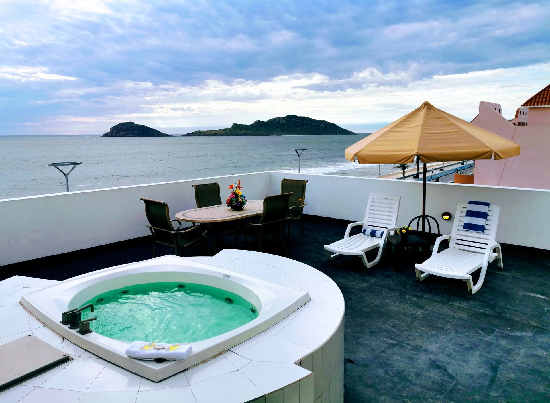 A jacuzzi on a rooftop overlooking the ocean