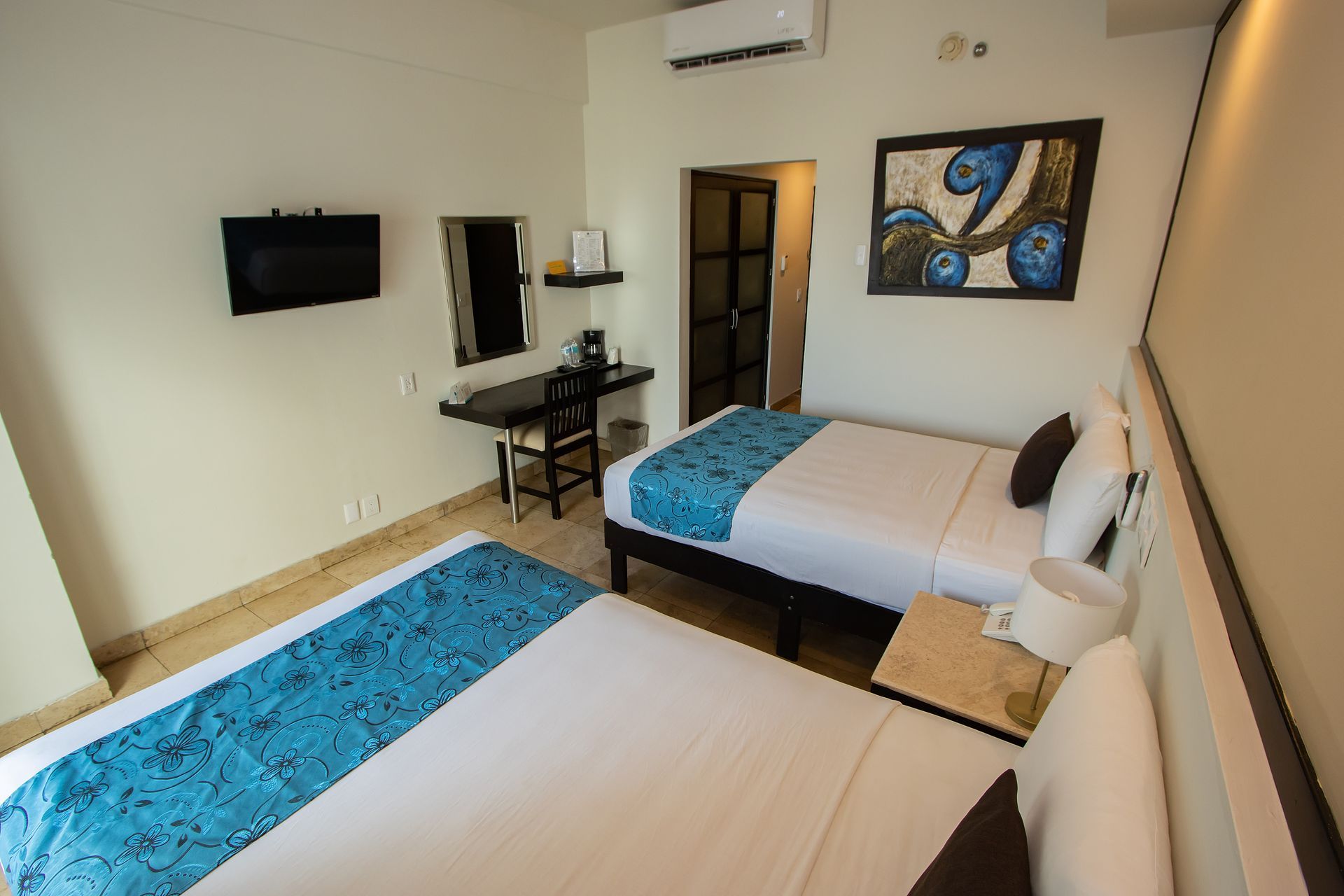 Una habitación de hotel con dos camas y un cuadro en la pared.
