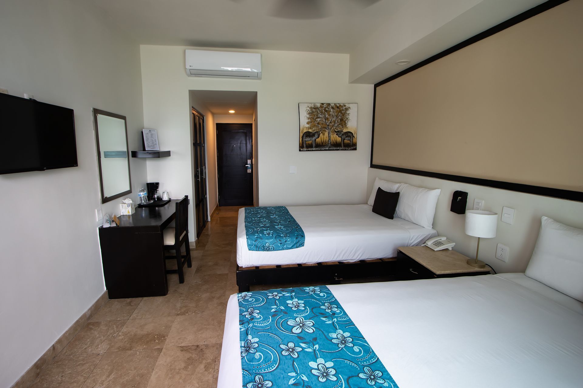 Una habitación de hotel con dos camas y un cuadro en la pared.