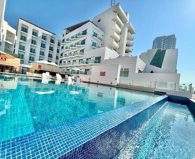 Un gran edificio con una piscina en frente.